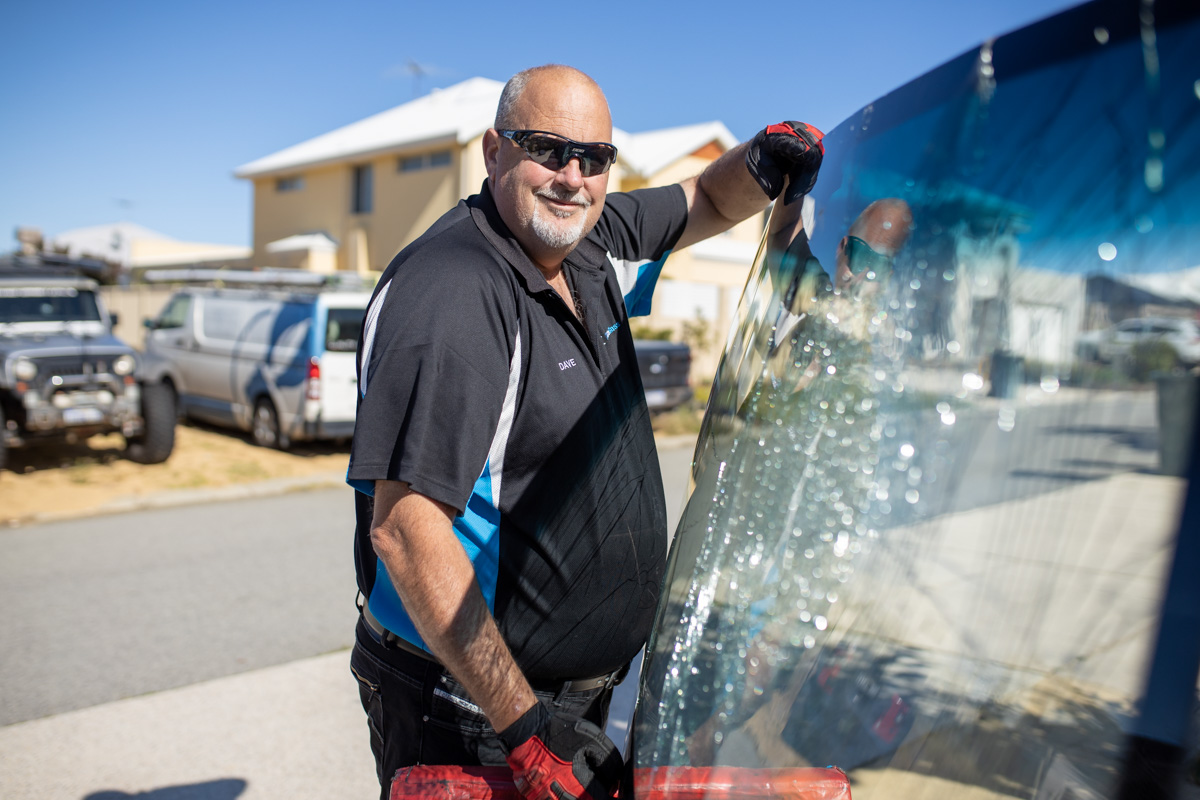 Man holding a broken pane of glass