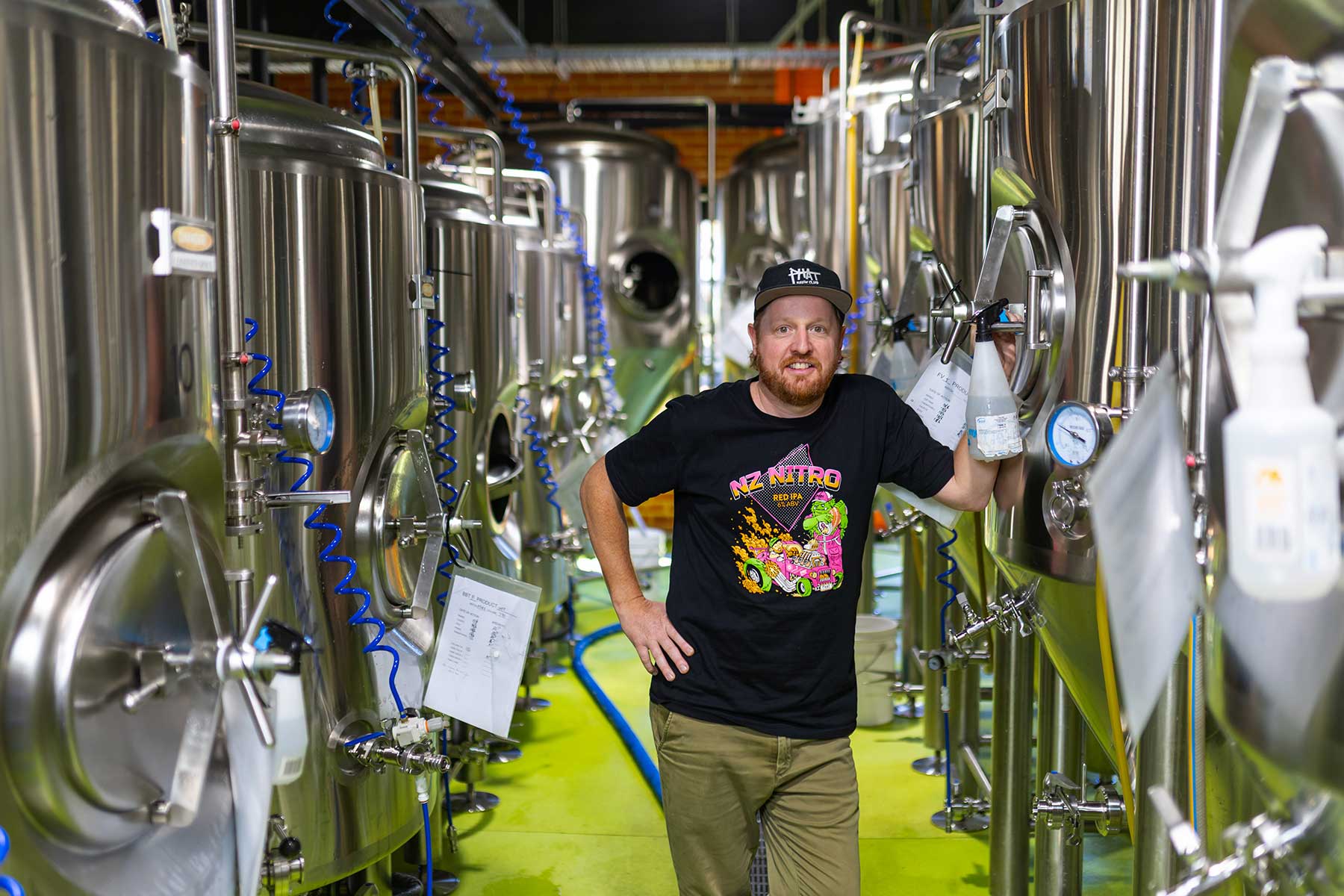 Image of a man standing in a brewery surrounded by brewing kettles