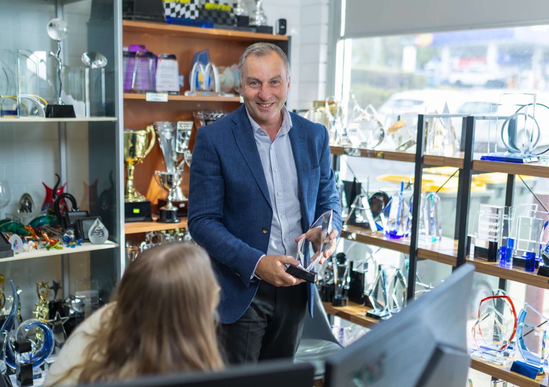 Image of Craigie Price, Director of Prime Trophies, holding one of their trophy products.
