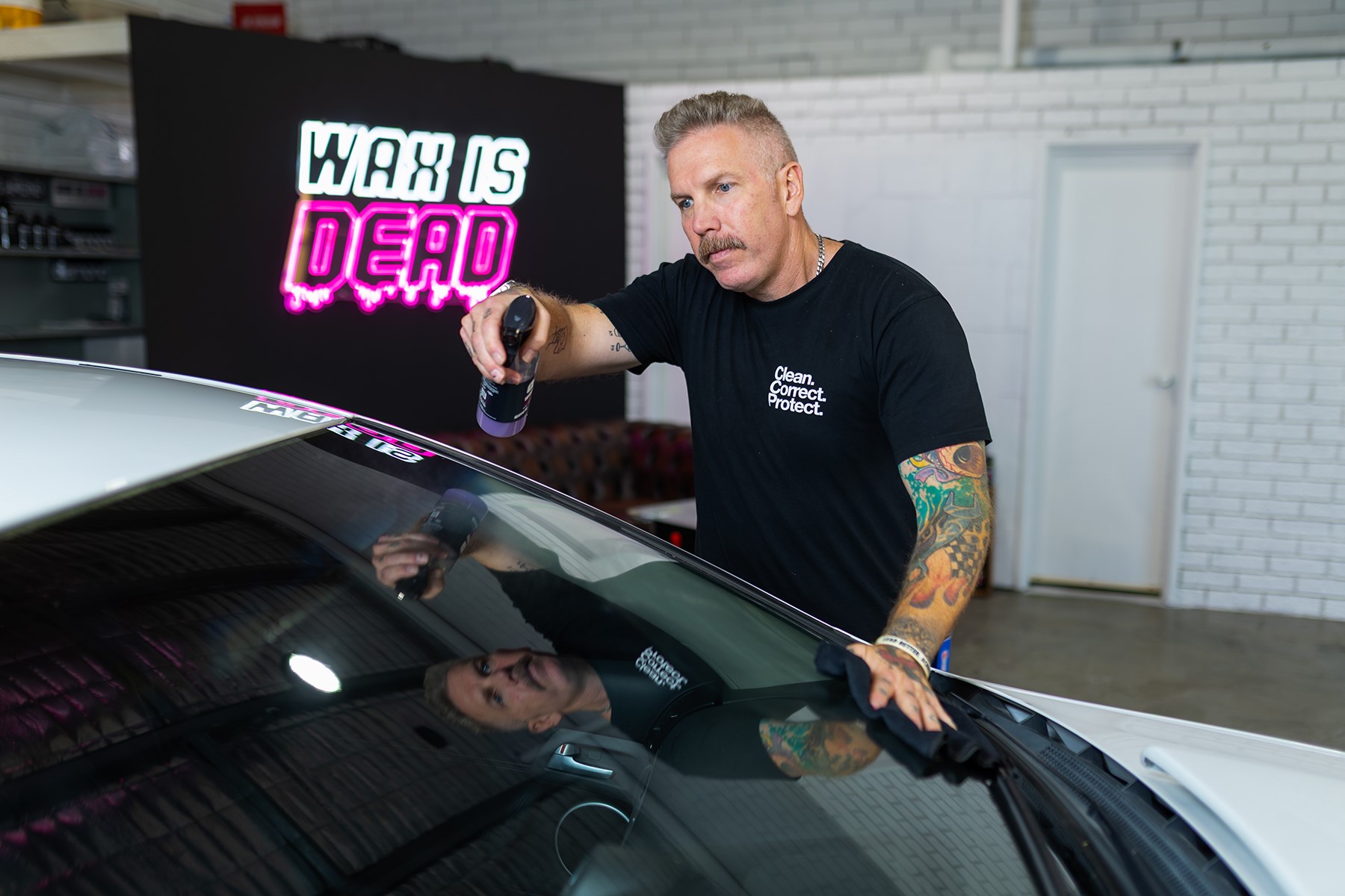 Photo of Paul Belczowski, owner of Diamond Detailing, working on a car.