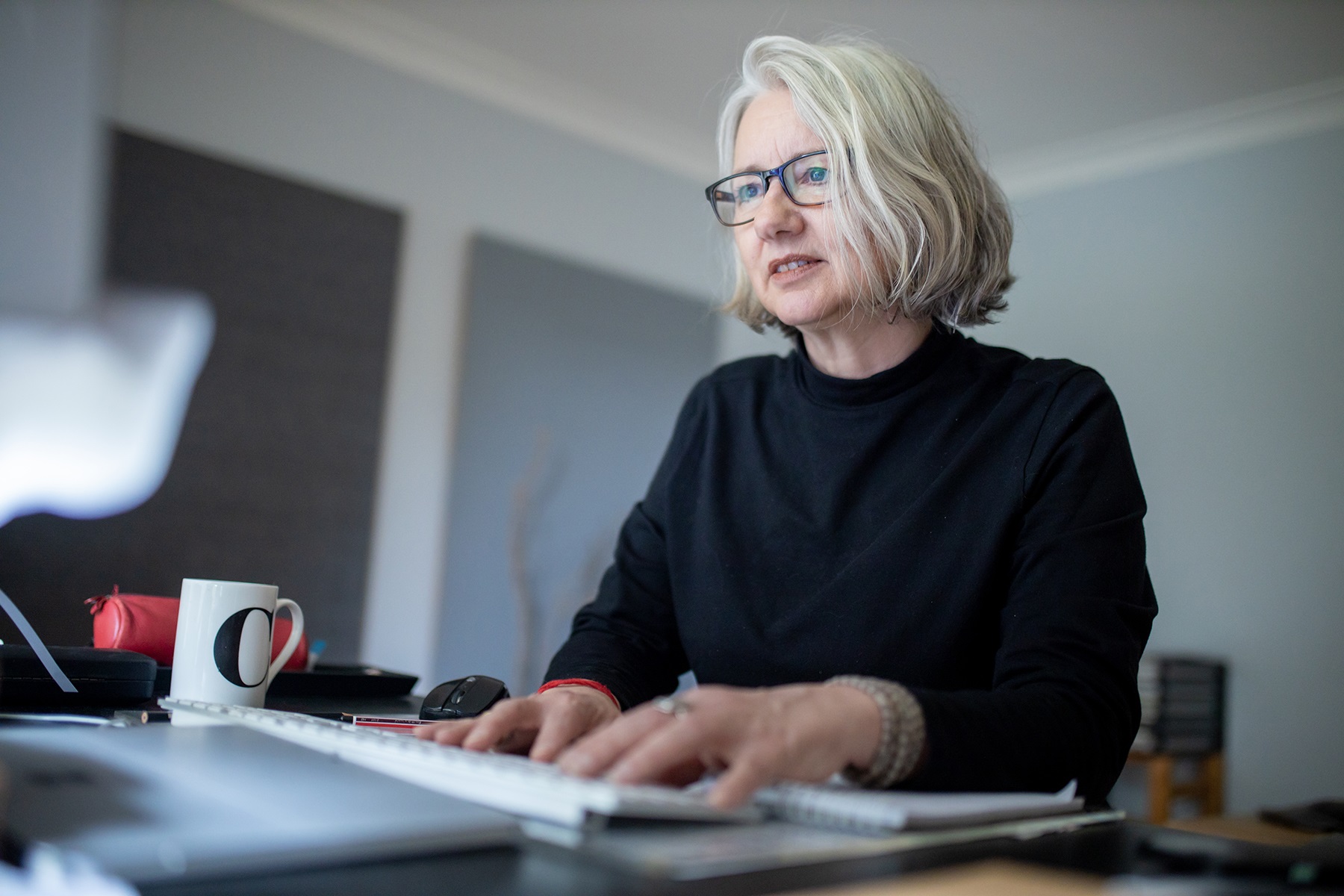 Photo of a female business owner typing on a keyboard.