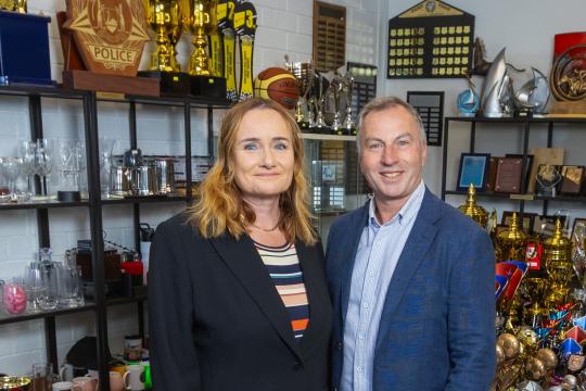 Image showing the two directors of Prime Trophies, Katya and Craigie Price, standing in their shop.