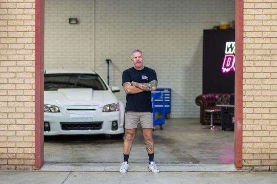 Photo of Paul Belczowski, owner of Diamond Detailing, standing at the entrance of his business premises.
