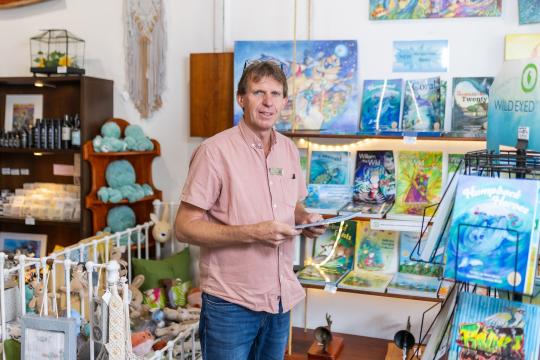 Mark White standing in his retail business, Wild Eyed Press.