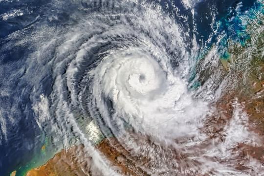Aerial view of a large cyclone approaching Western Australia, with swirling cloud patterns visible from above.