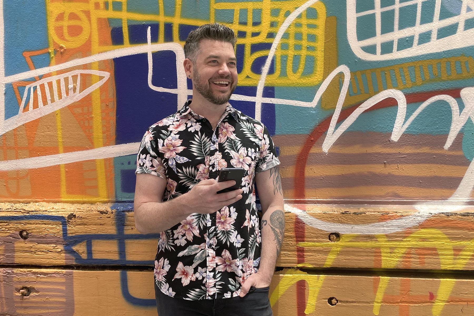 Photo of a man holding a smart phone.