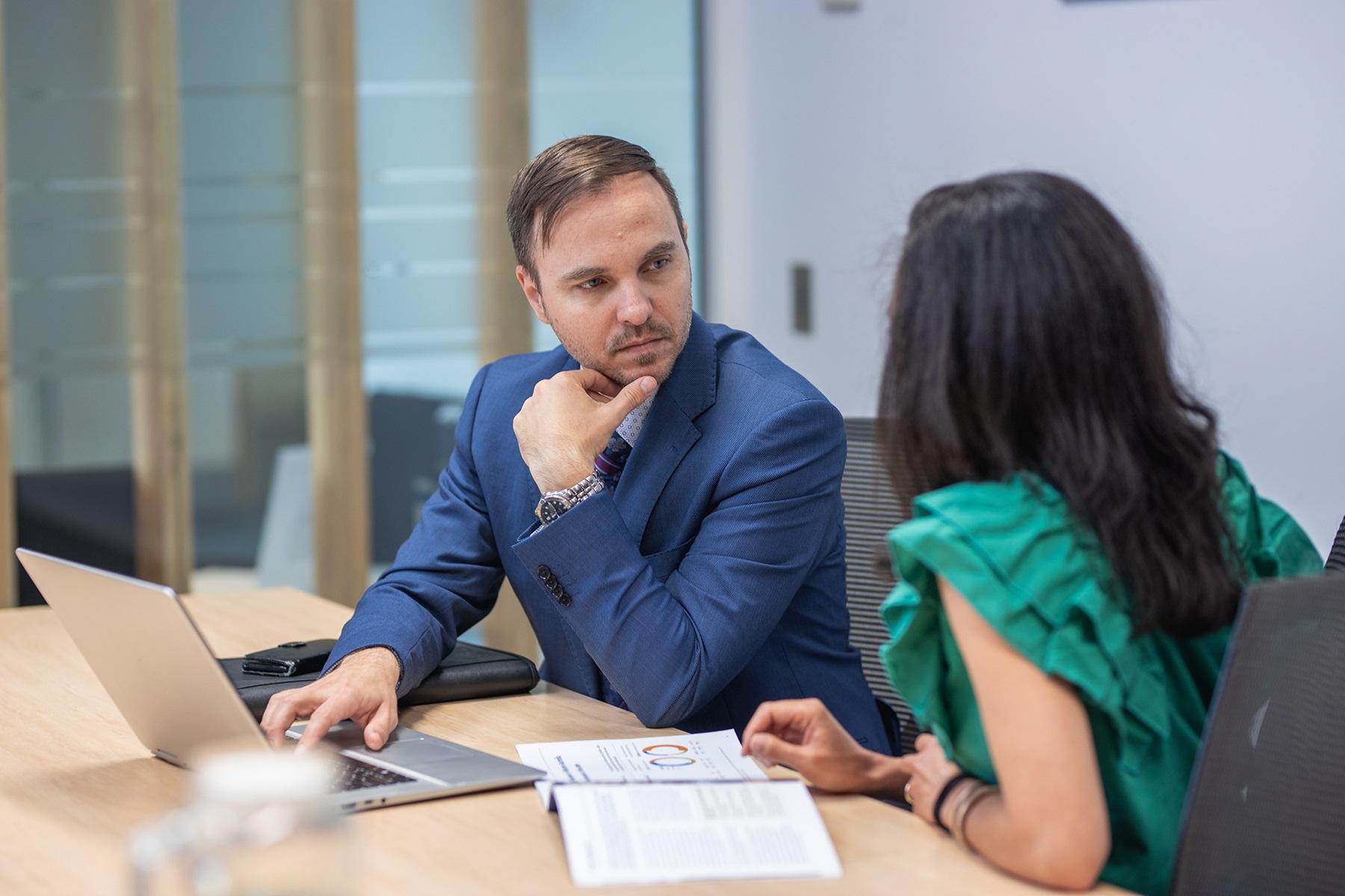 Photo of a man and a woman sitting at a table, having a conversation.