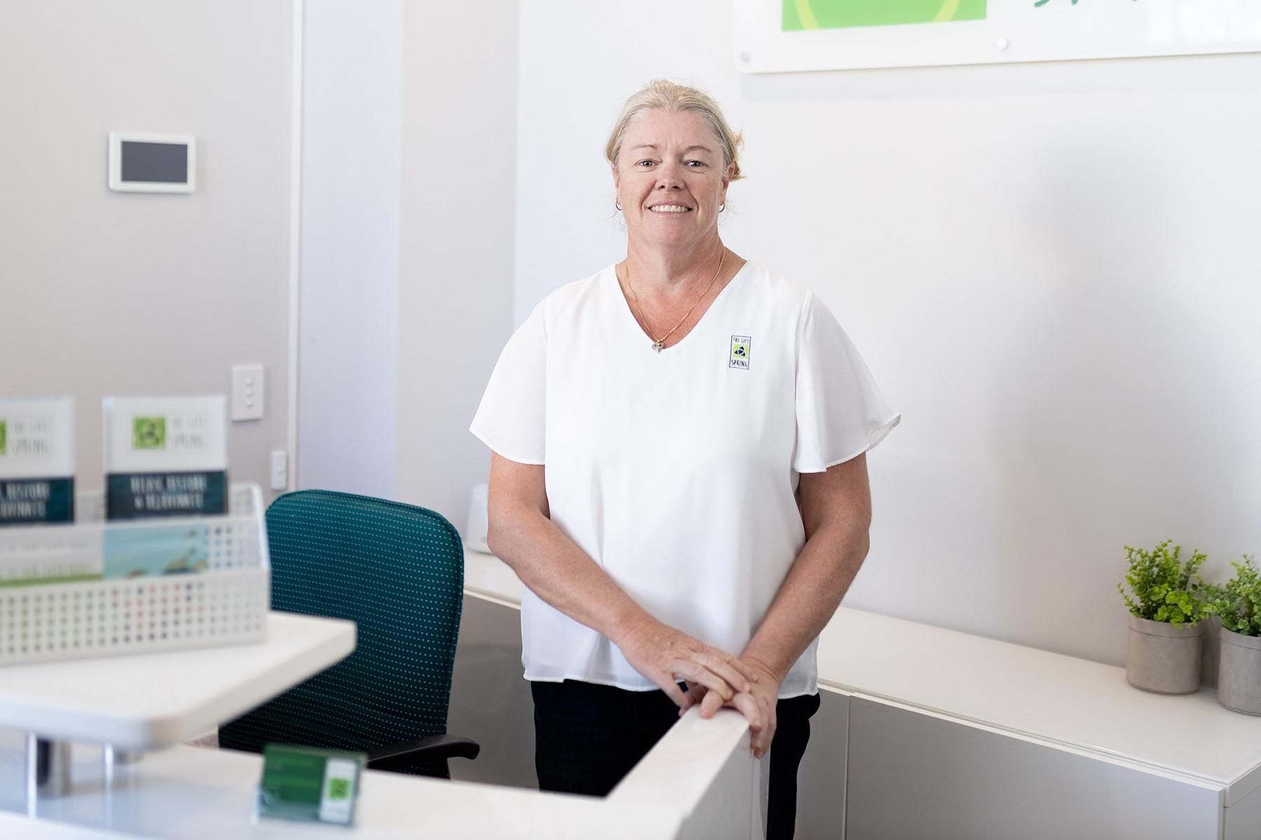 Photo of a woman standing behind the counter at her business premises.