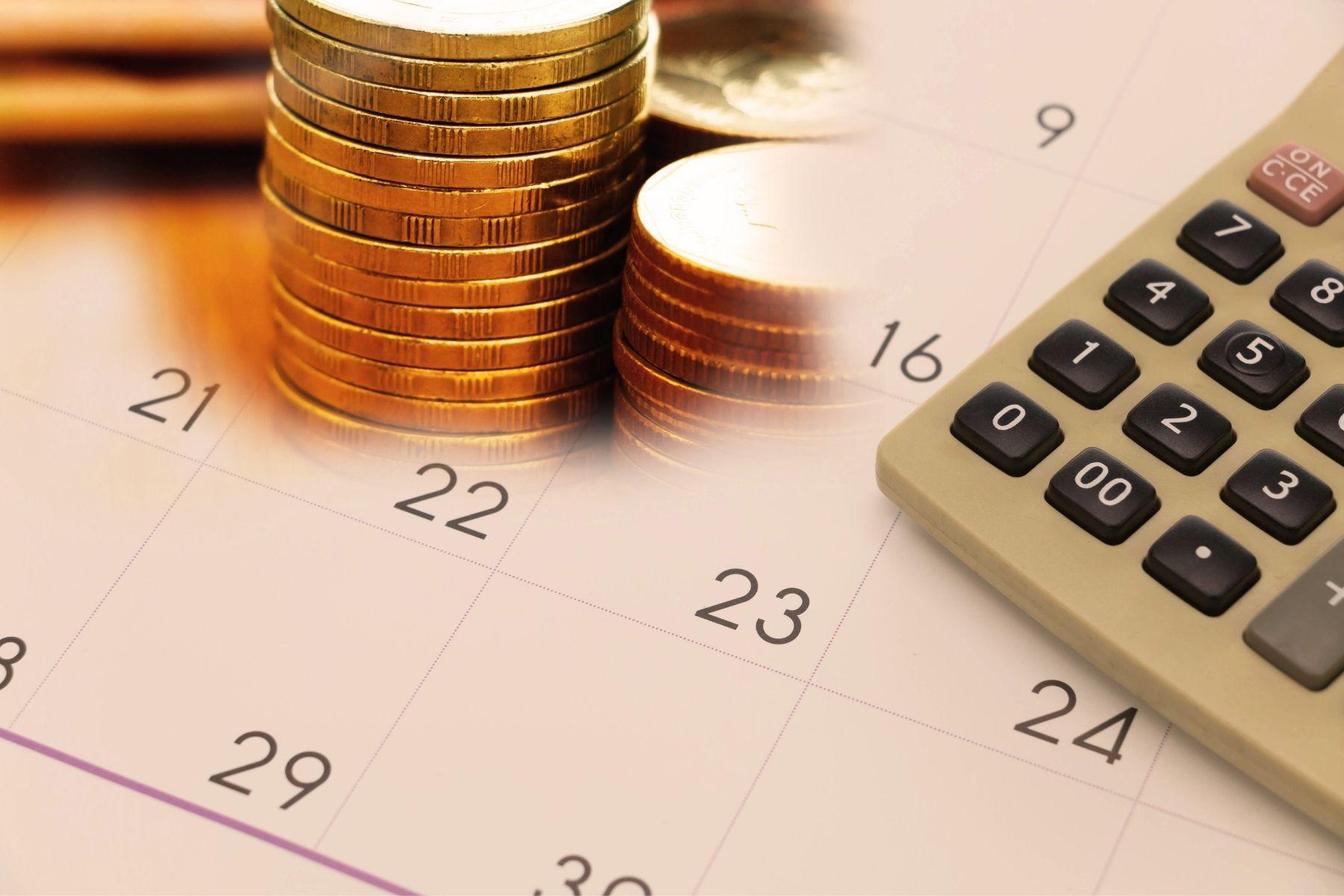 Image of calculator and coins on a calendar