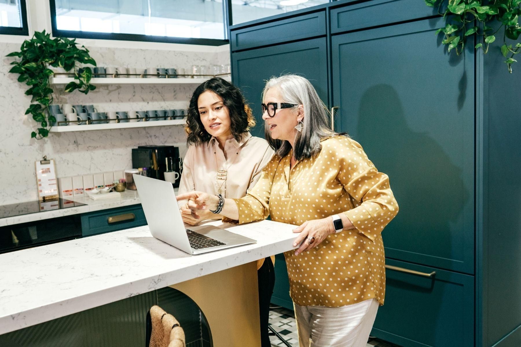 Photo of two women working together on a laptop.