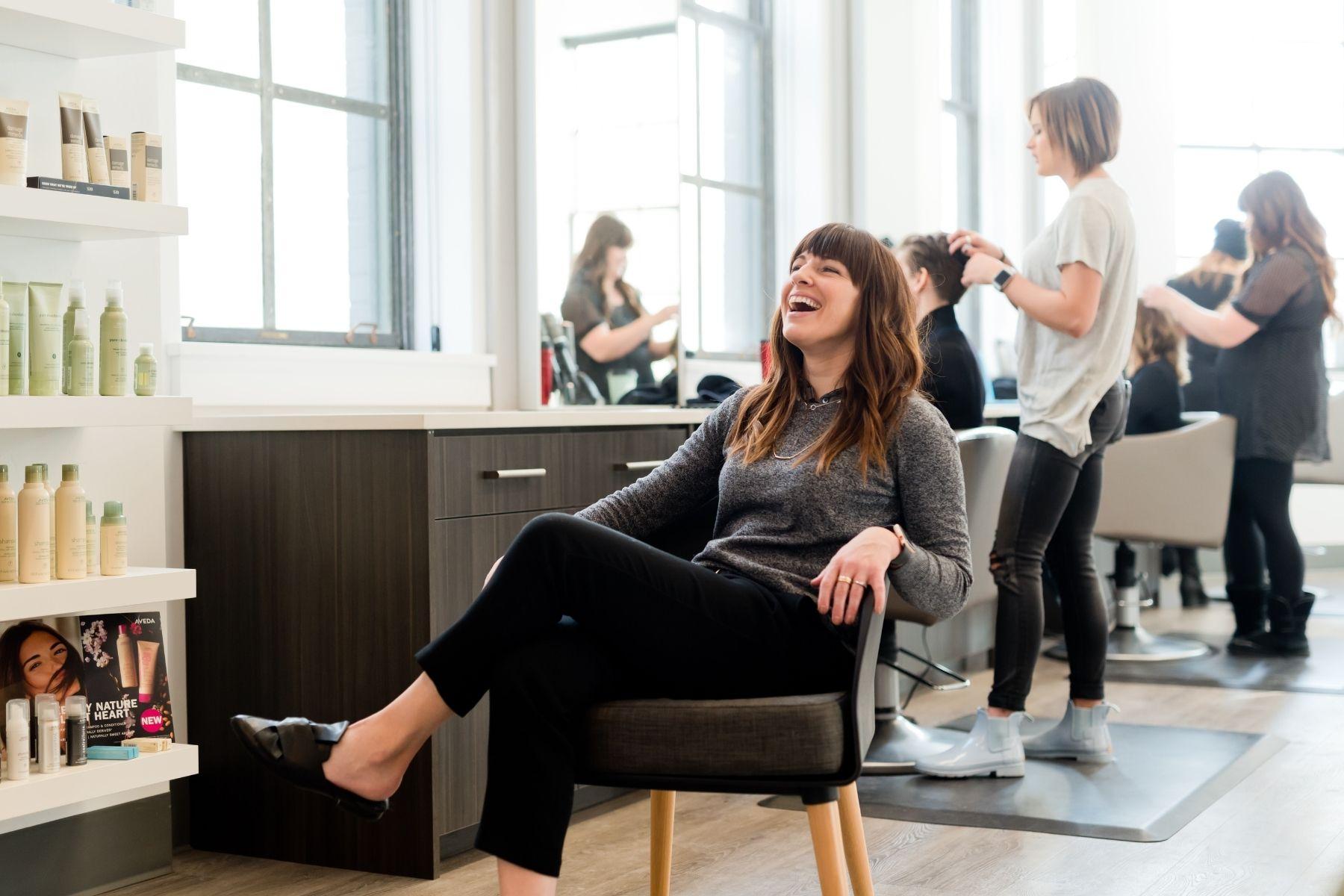 Photo of a woman smiling in a hair salon.