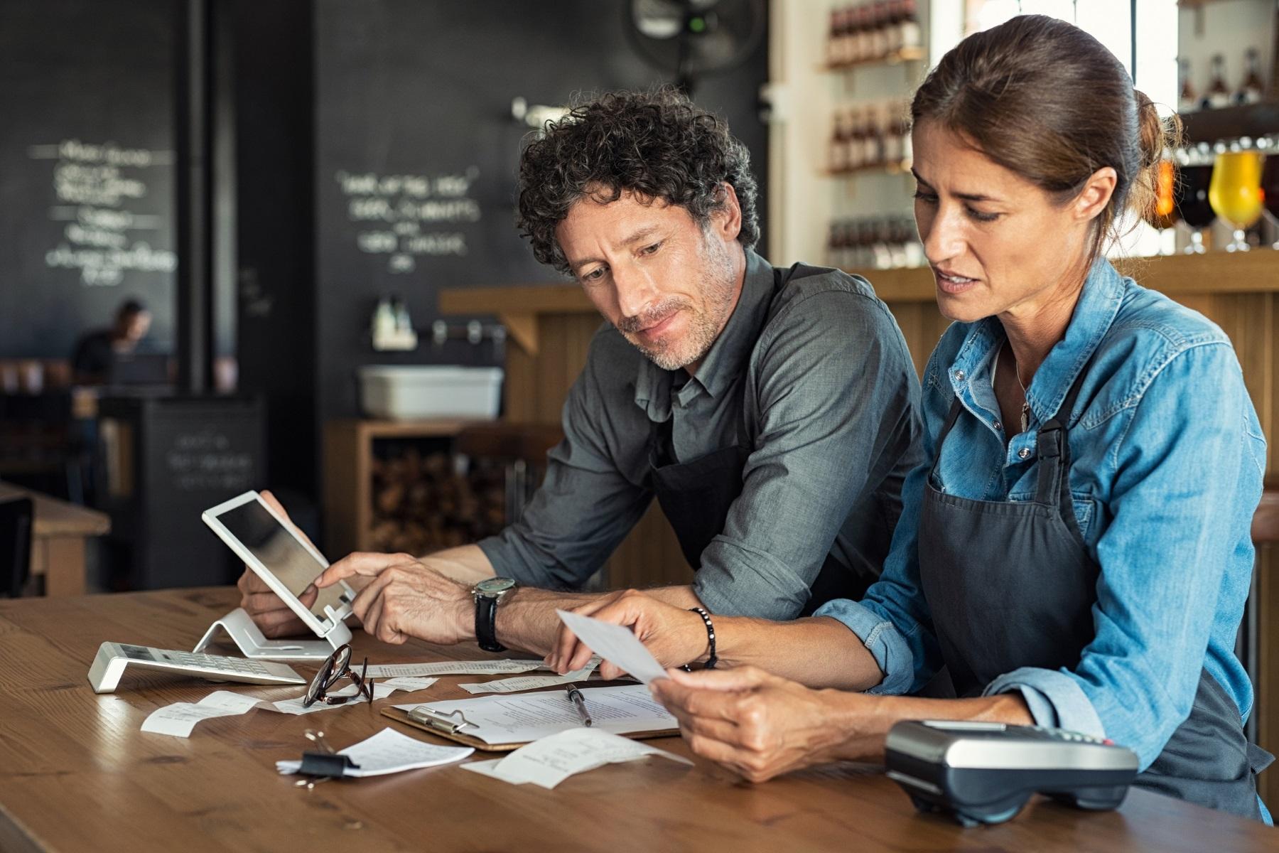 Photo of a man and woman sitting at a table. They are reviewing paperwork.