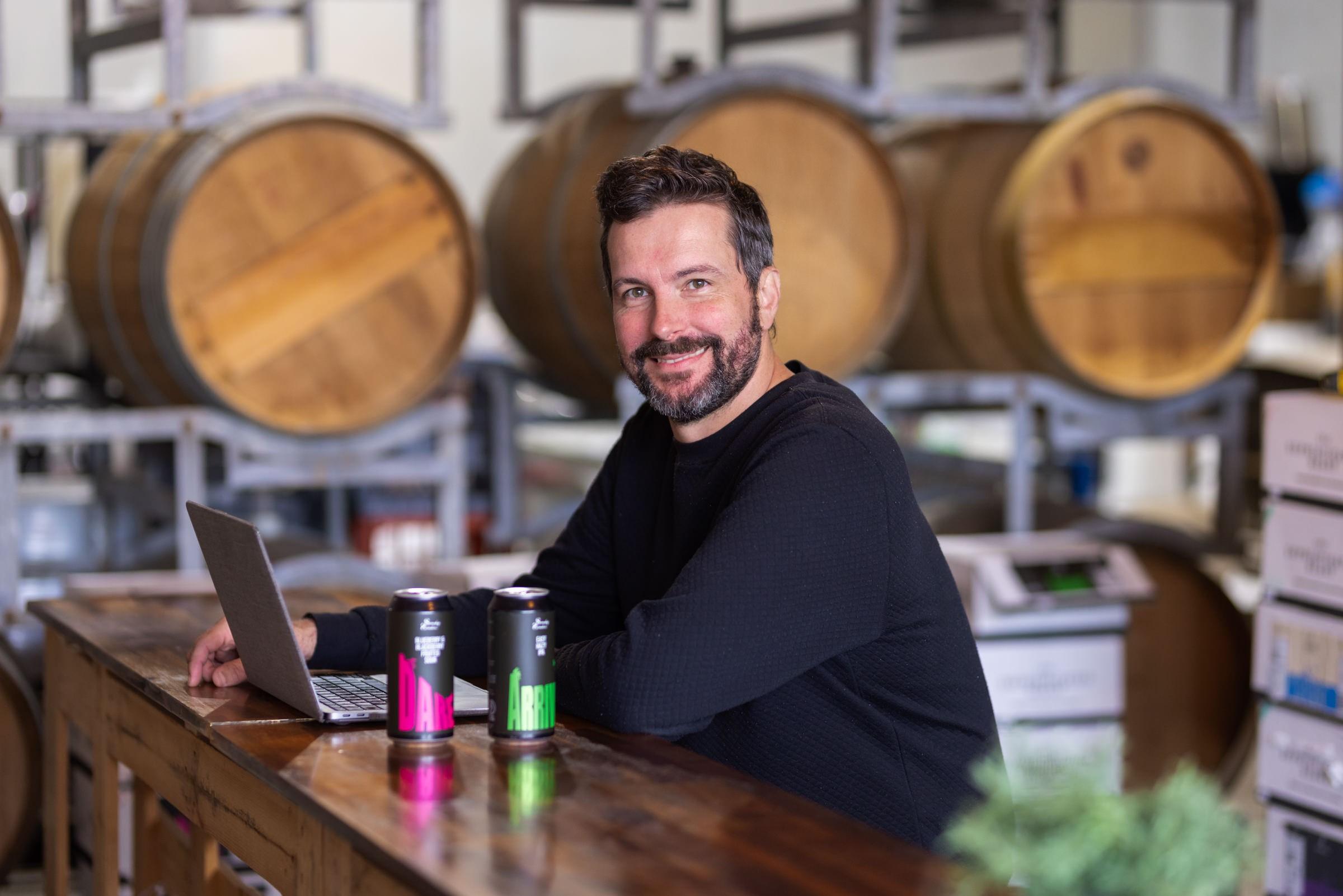 Image showing Ryan White, founder of Someday Somehow, sitting in the brewing cellar.