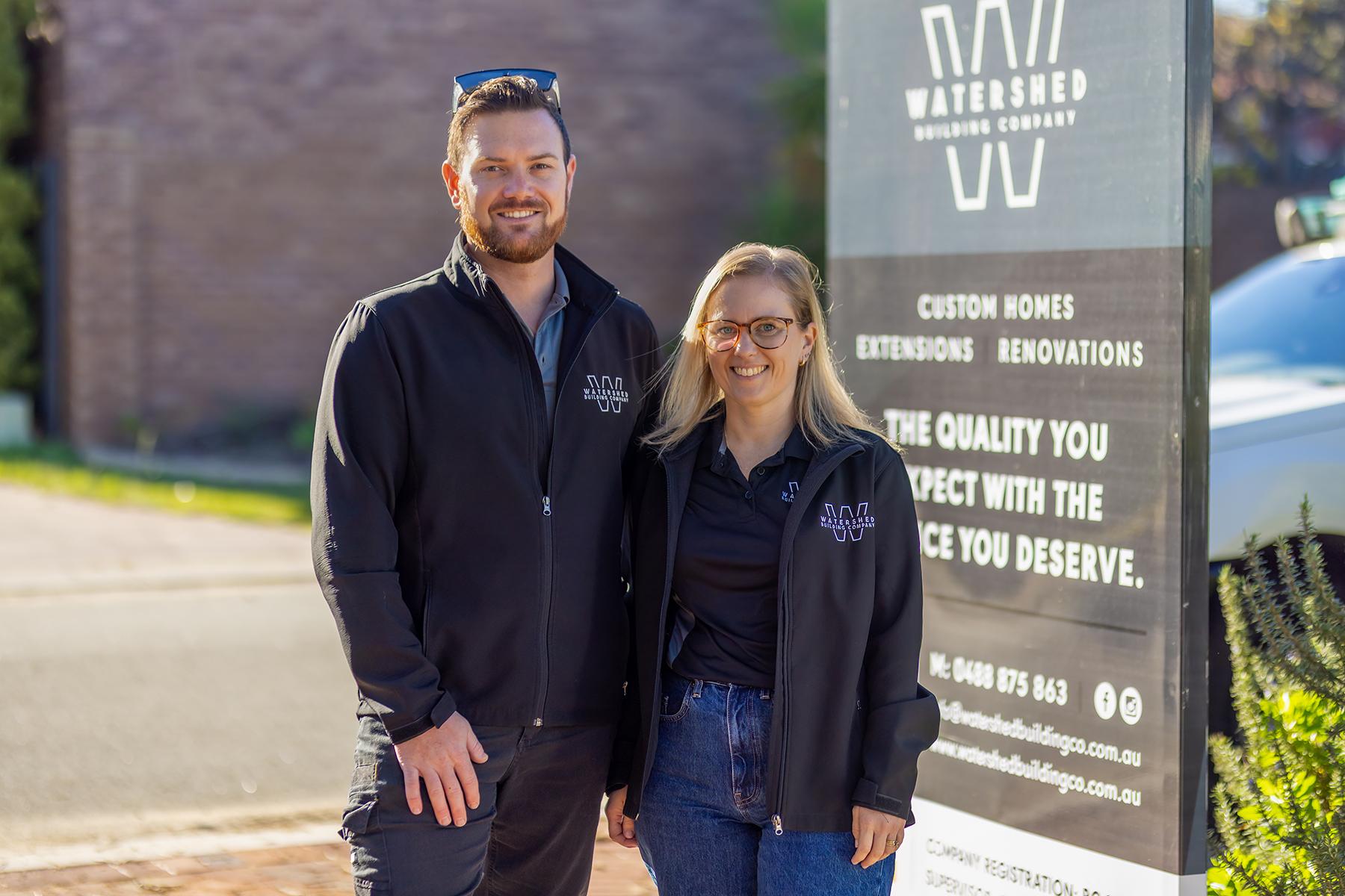 Evan and Casey Turners standing at the entrance to their business, Watershed Building Company.