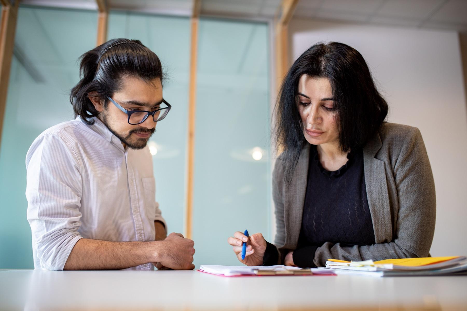 A photo of a man and a woman reviewing paperwork.