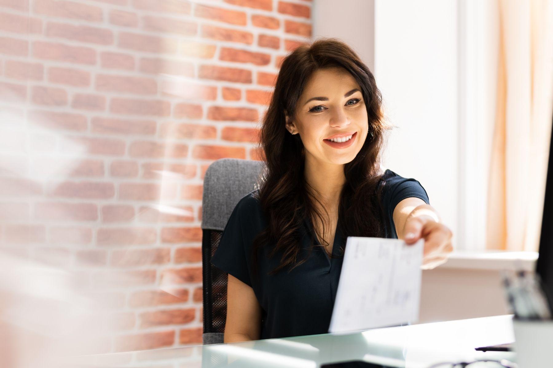 Photo of a female business owner looking over paperwork at her desk.