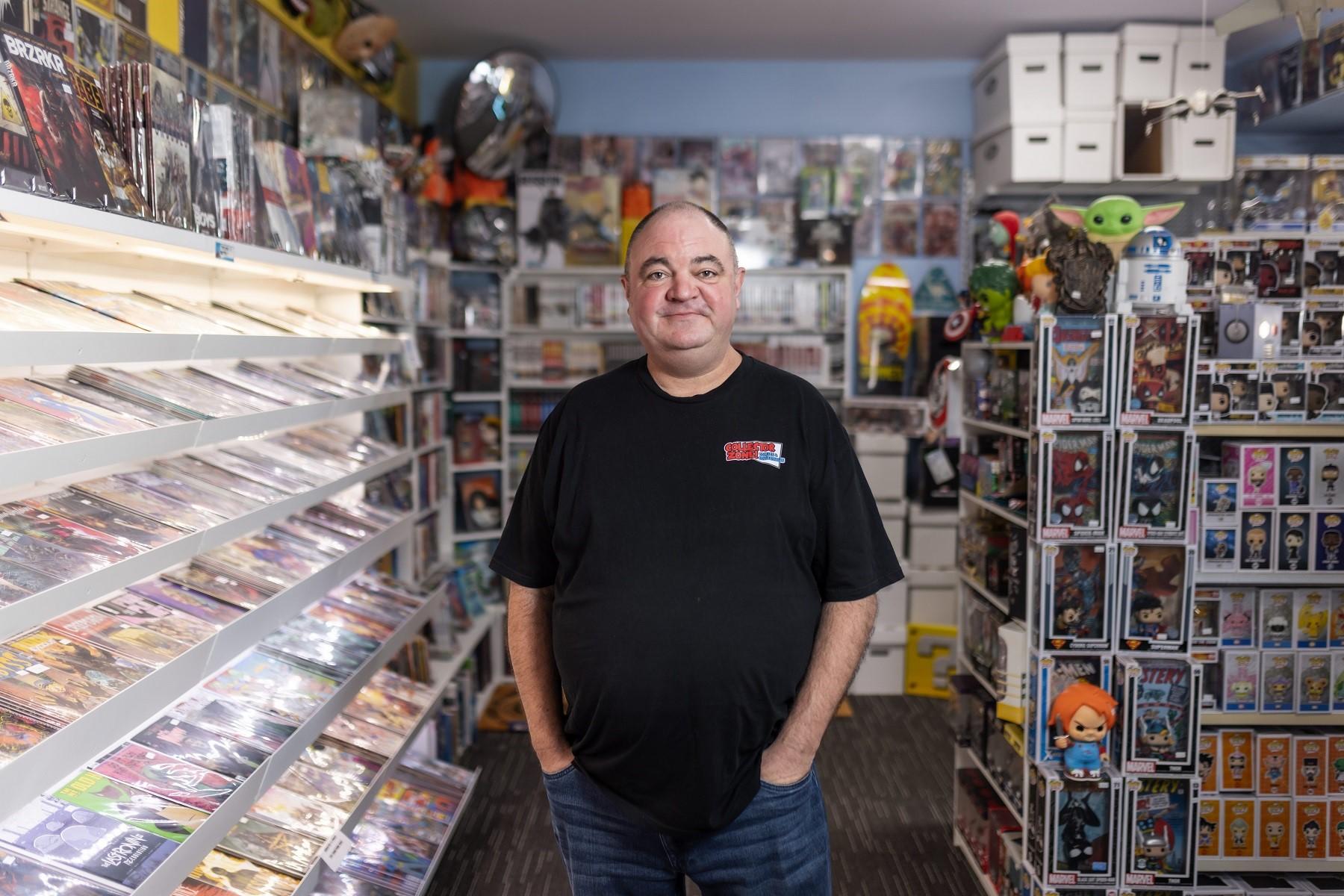 Photo of Chris Topfer, owner of Collector Zone!, standing in his retail store located in Clarkson.