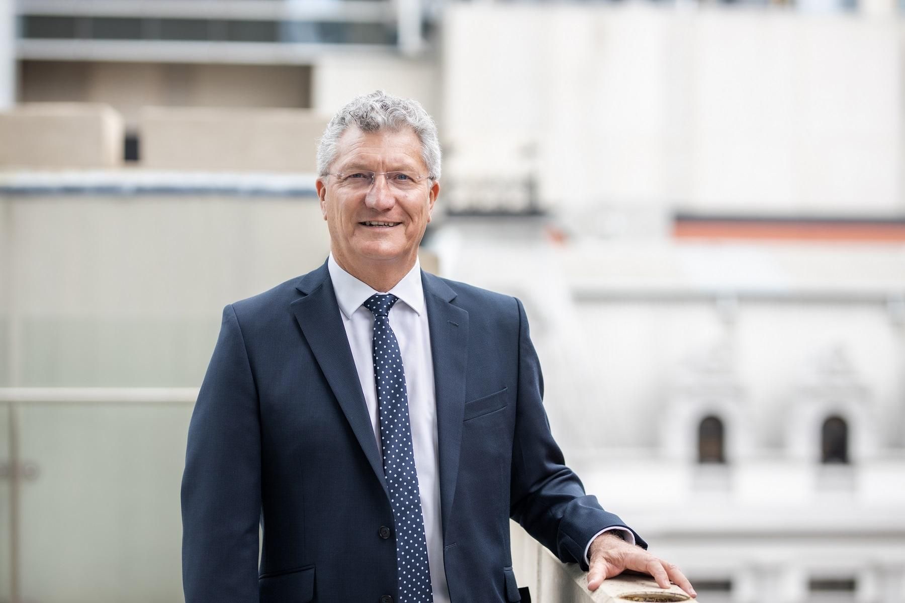 Small Business Commissioner David Eaton outside leaning on a balcony looking at the camera