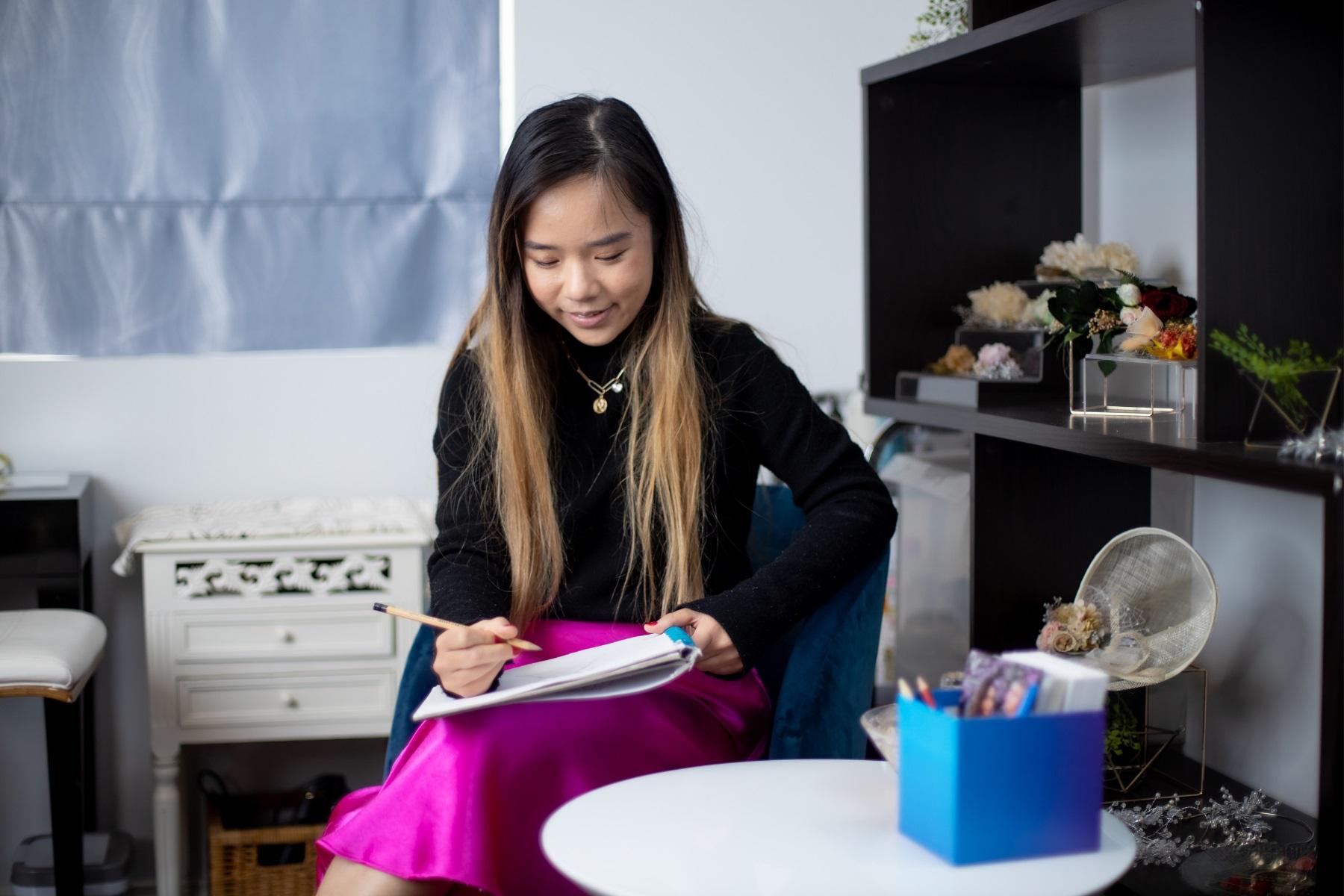 Photo of a woman writing in a notebook.