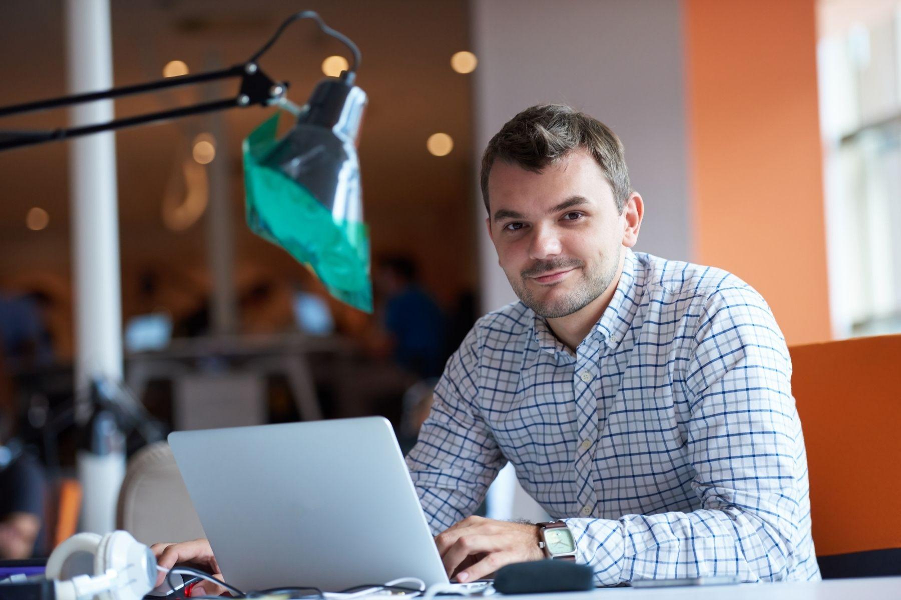 Photo of a man working at a laptop.