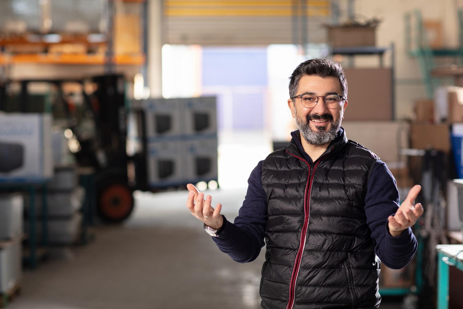Photo of a man standing in a warehouse.