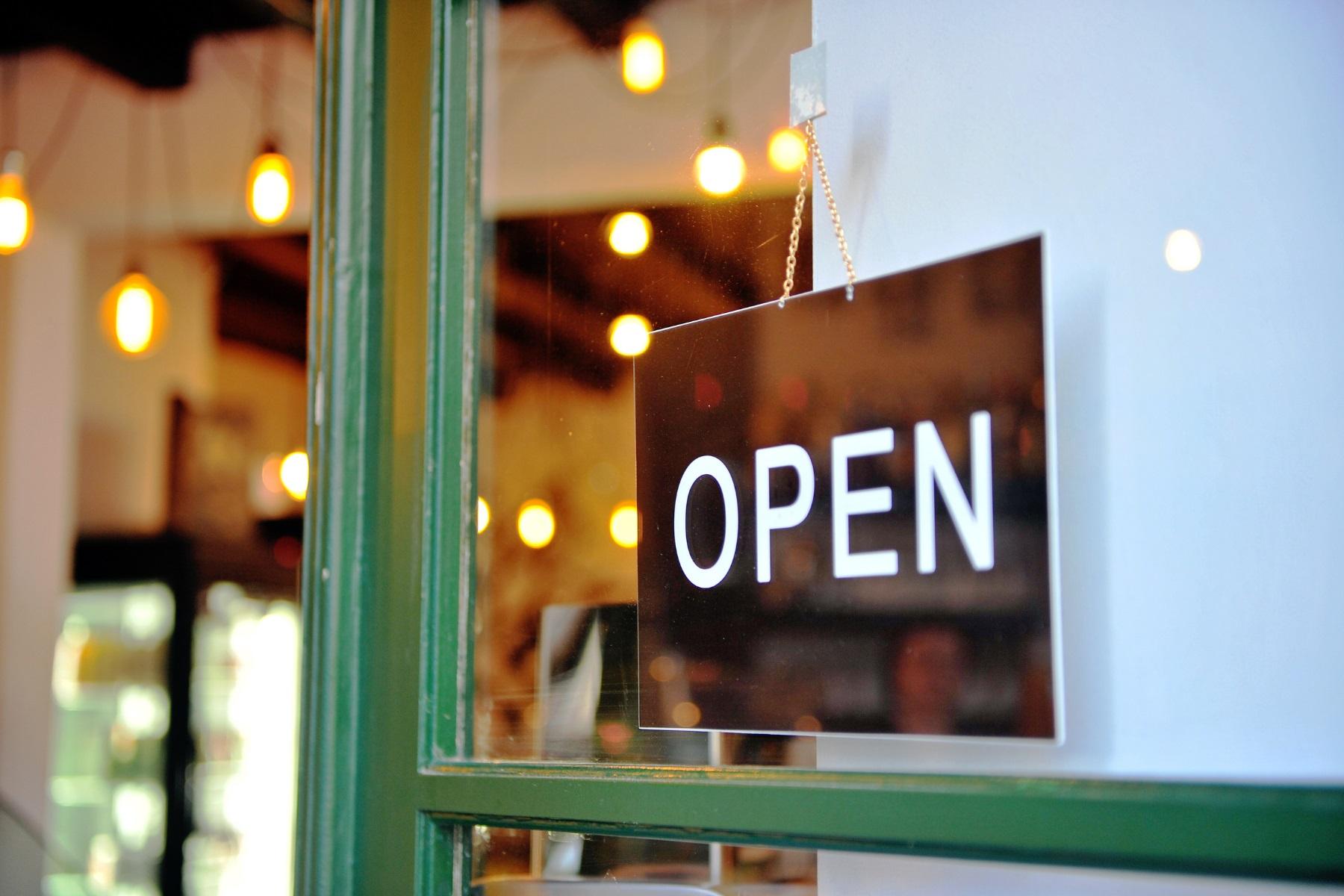 Photo of a shop window with an open sign in it.