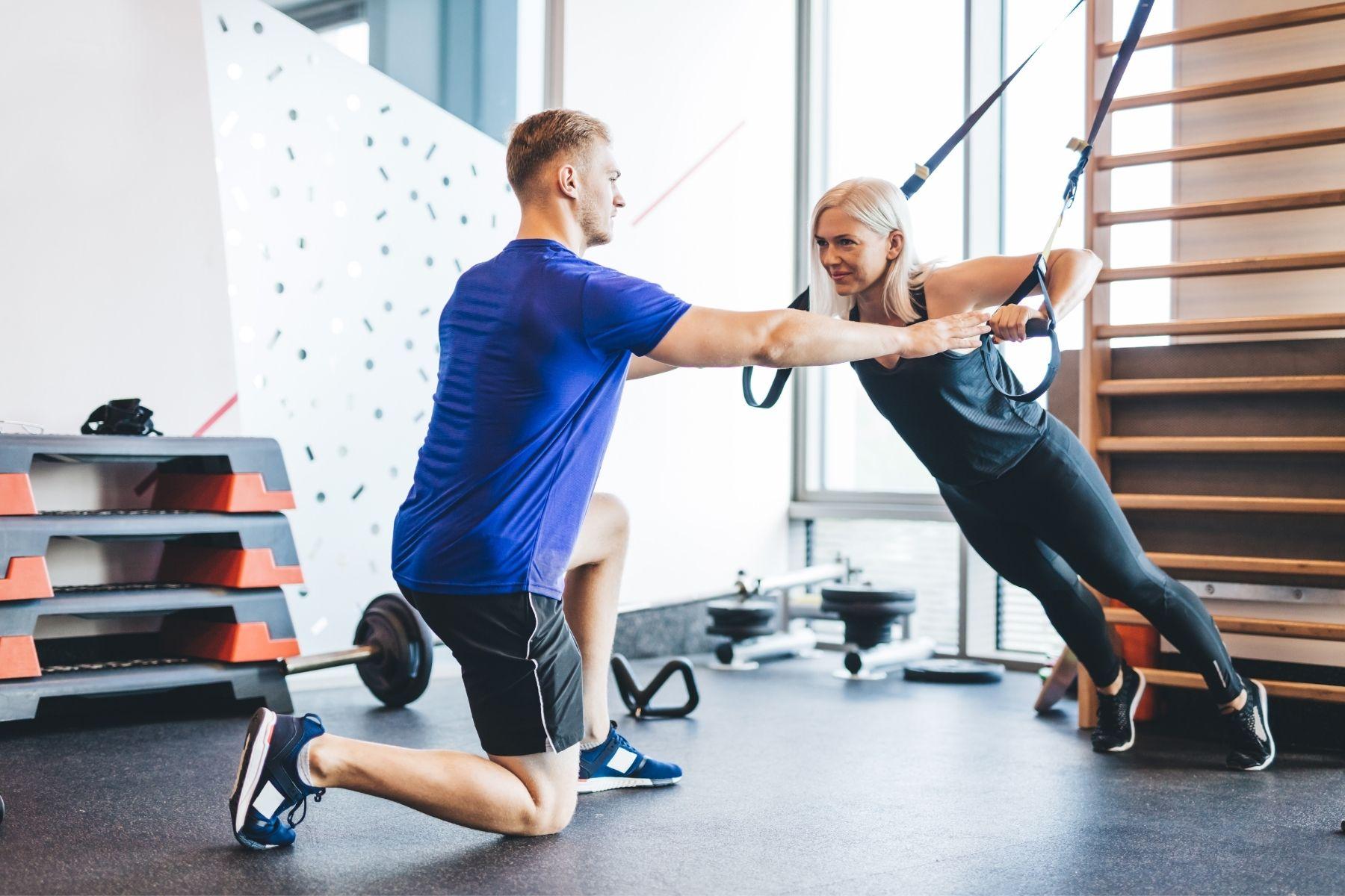 Photo of a personal trainer working our a client.