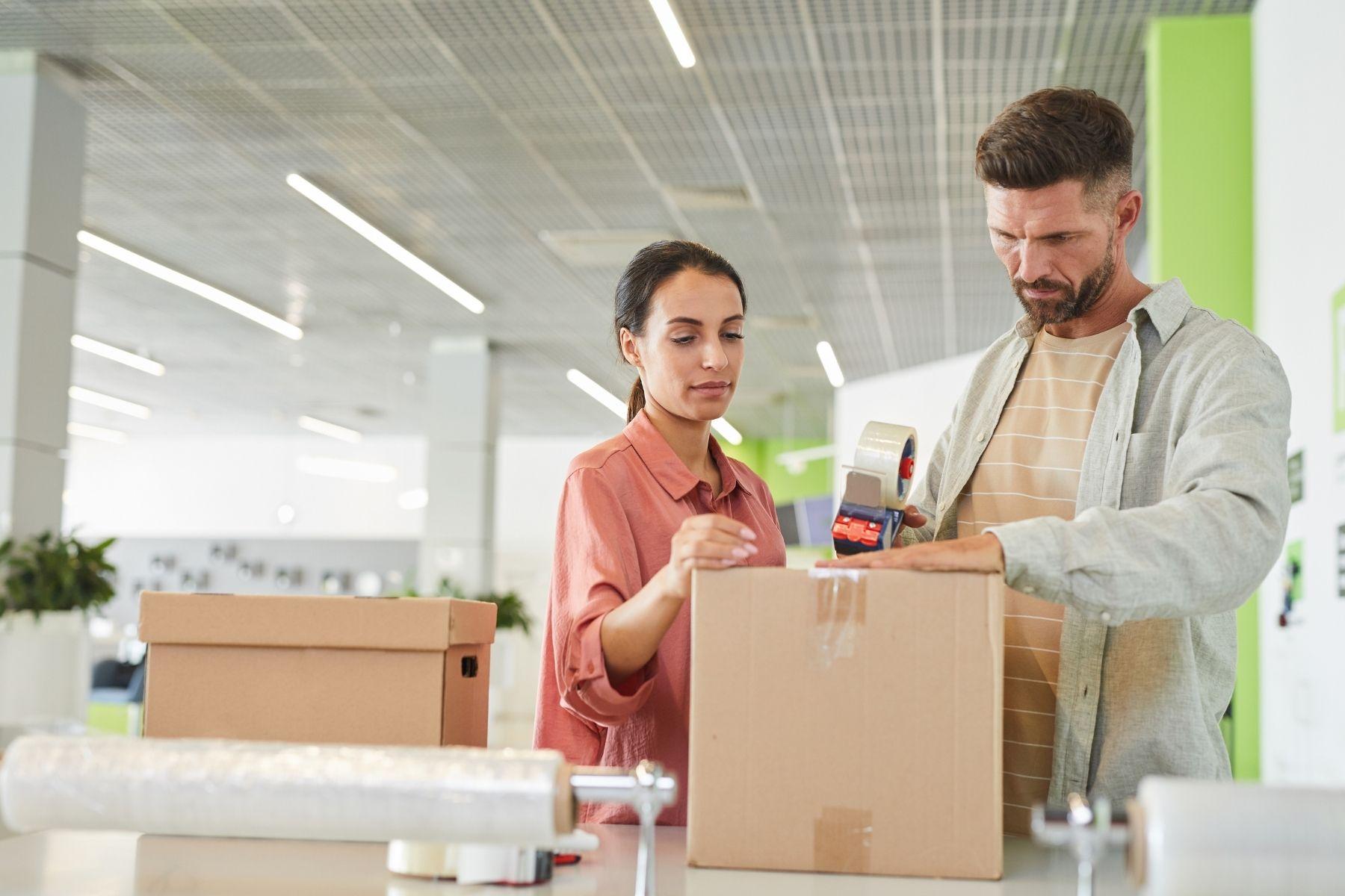 Photo of a man and woman placing items in a box.