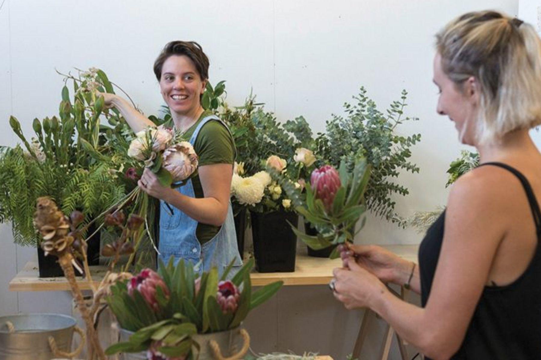 A photo of two women working in a florist.