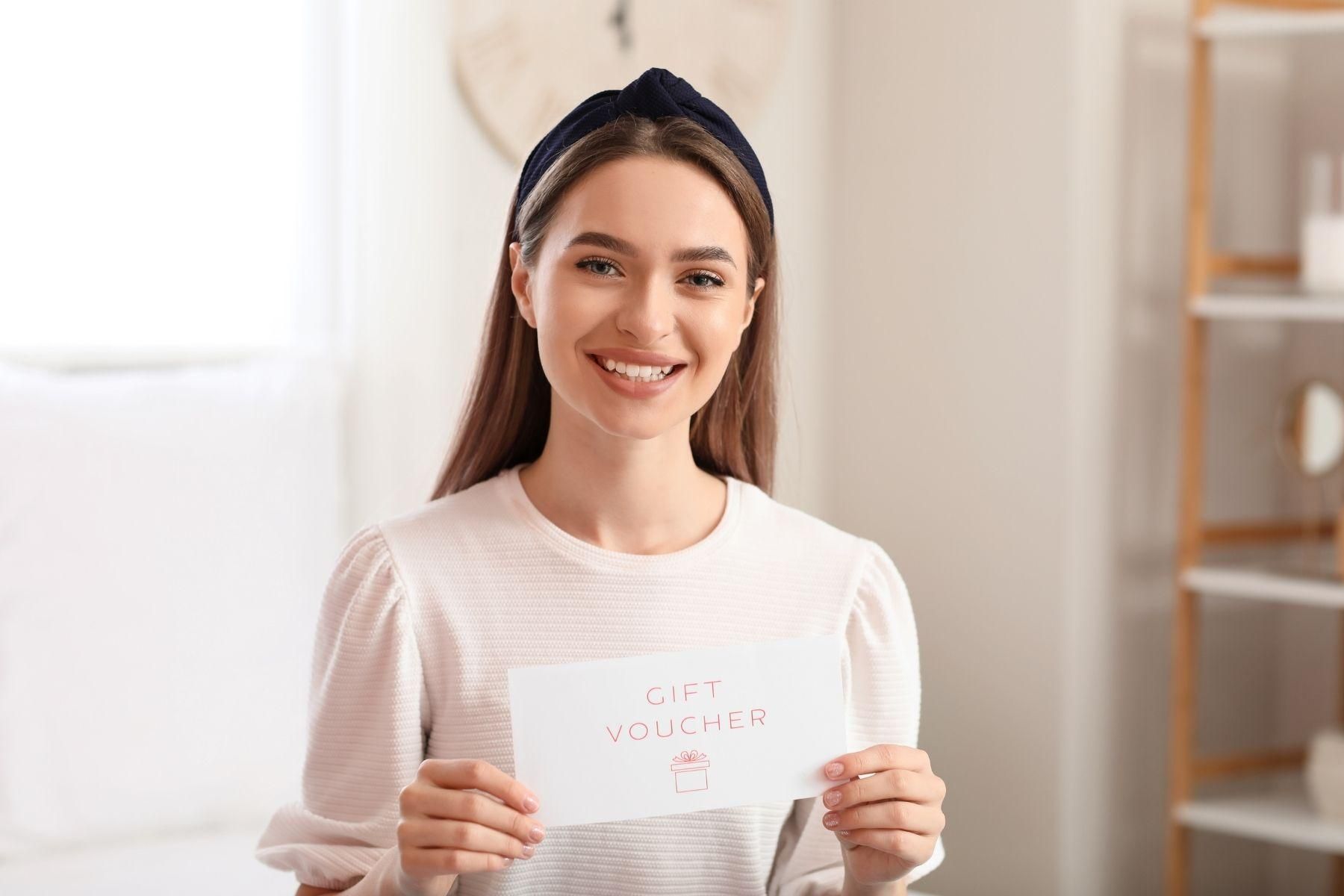 Photo of a young woman holding a gift card.
