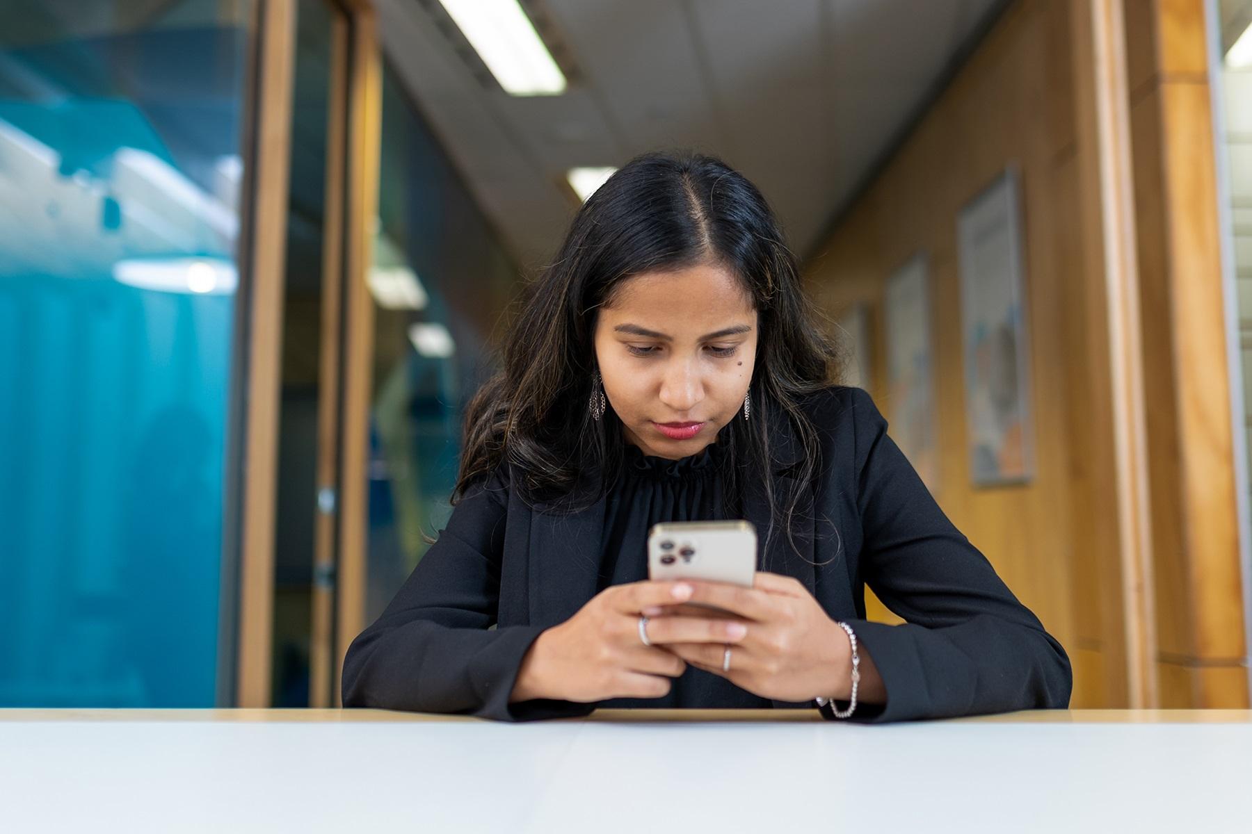 Photo of a woman looking at a smart phone.