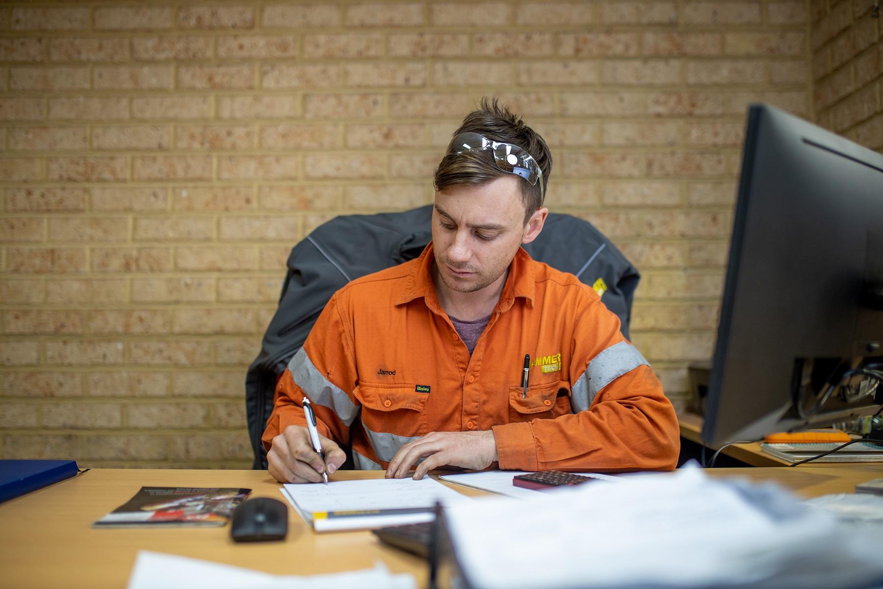 Photo of a male business owner doing paperwork at his desk.