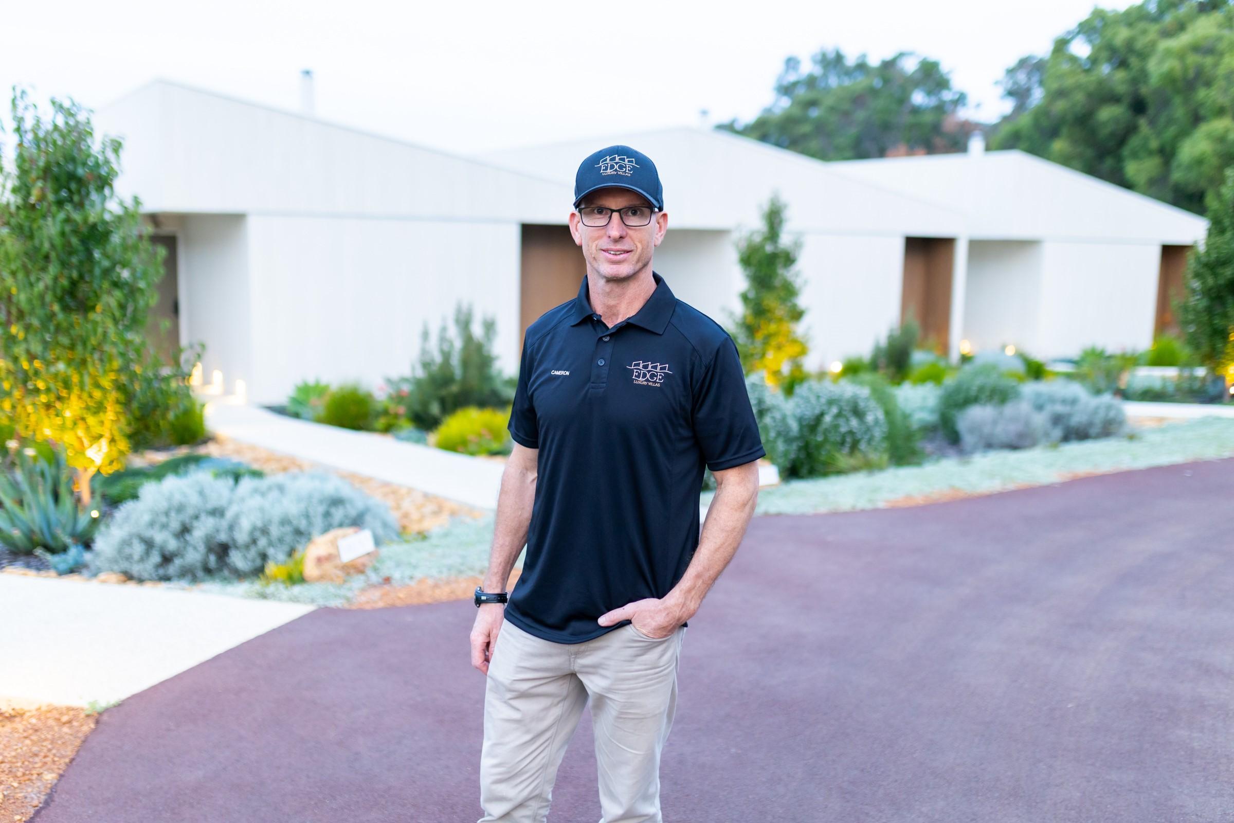 Image showing the owner, Cameron Kissell, standing beside Edge Luxury Villas.