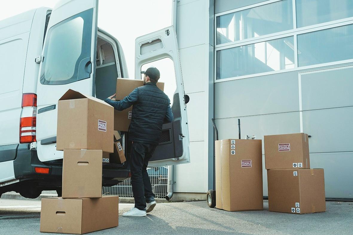 Photo showing a person loading a box into a delivery van.