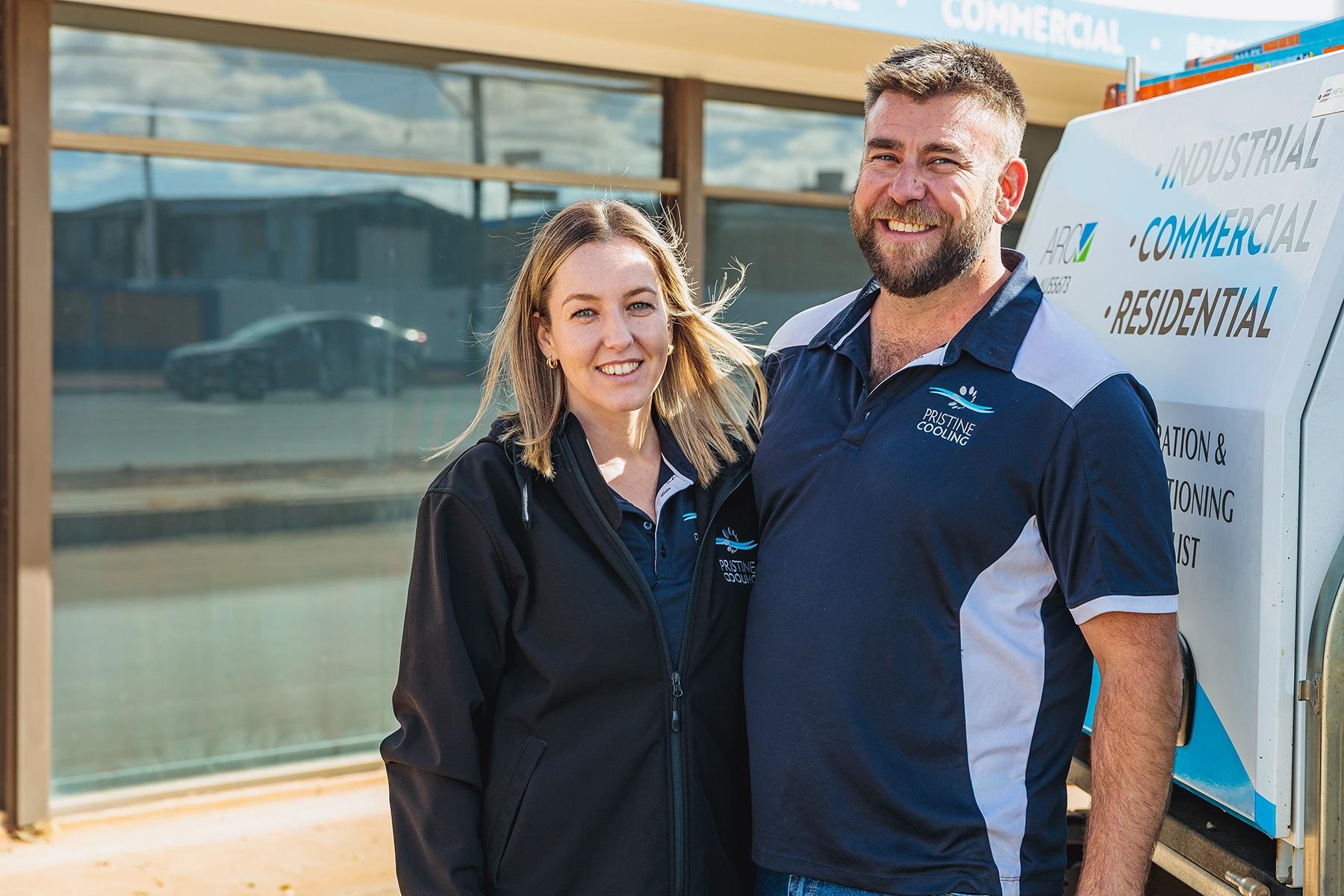 Photo of a man and woman standing outside of their industrial cooling business.