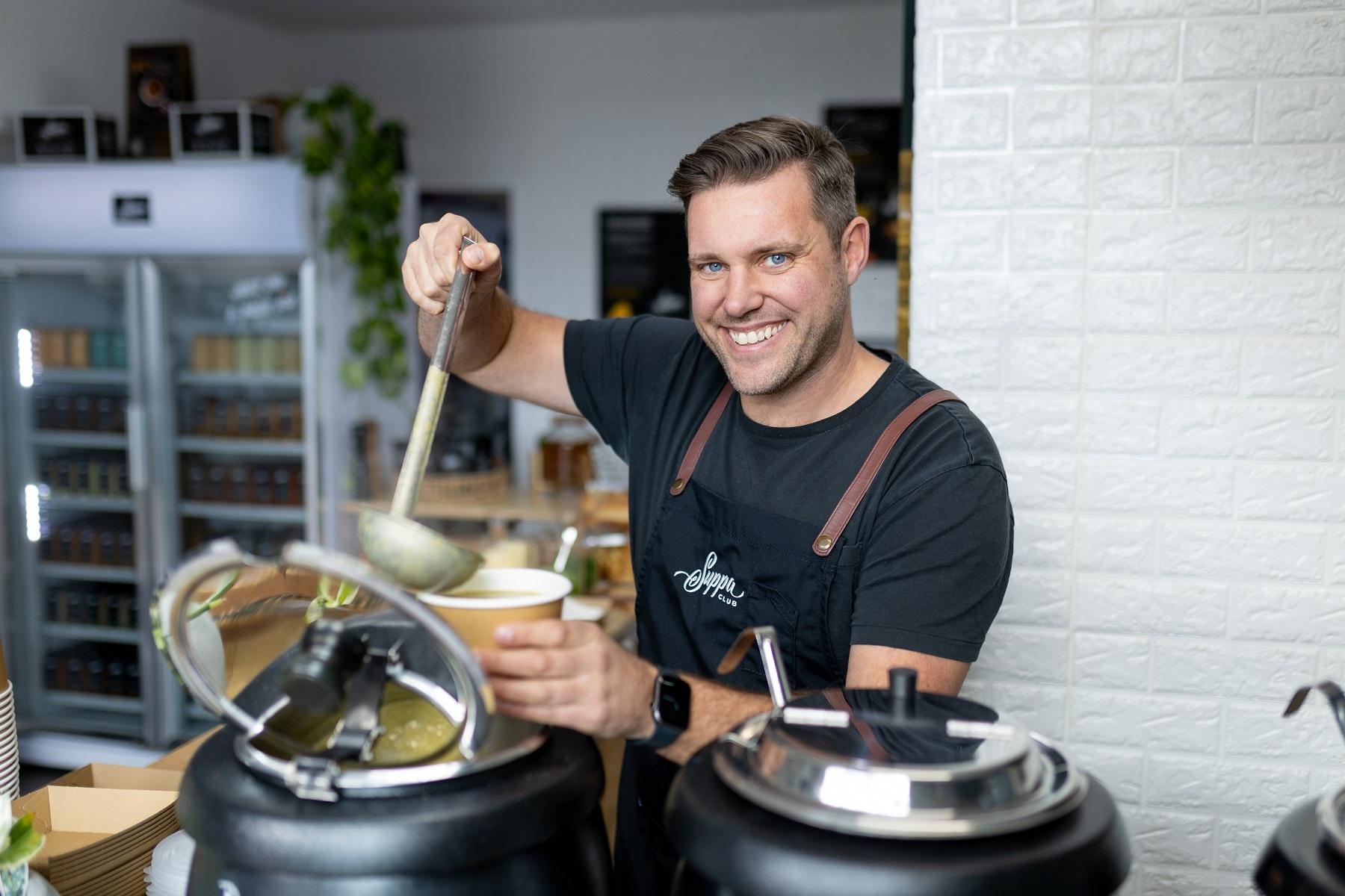Photo of Suppa Club Founder David Kane pouring soup into a bowl.