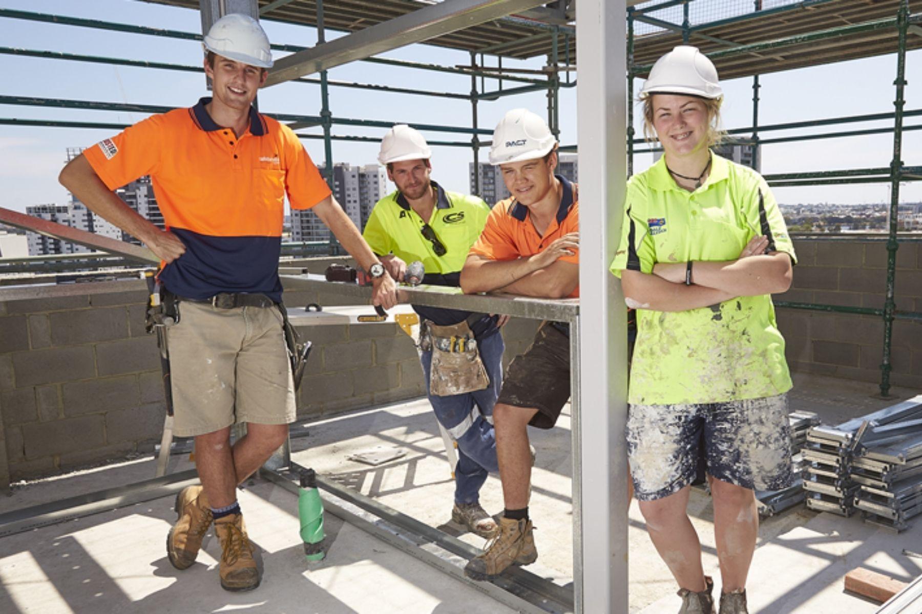 Photo of construction workers with hard hats and high vis clothing on site.