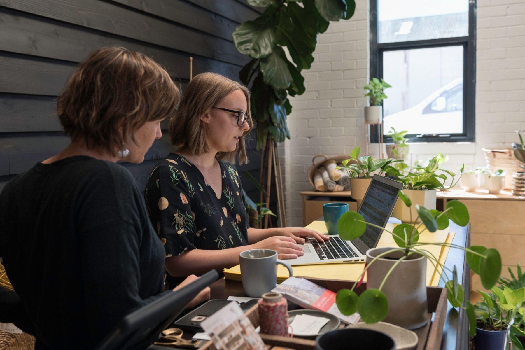 Photo of two women working together.