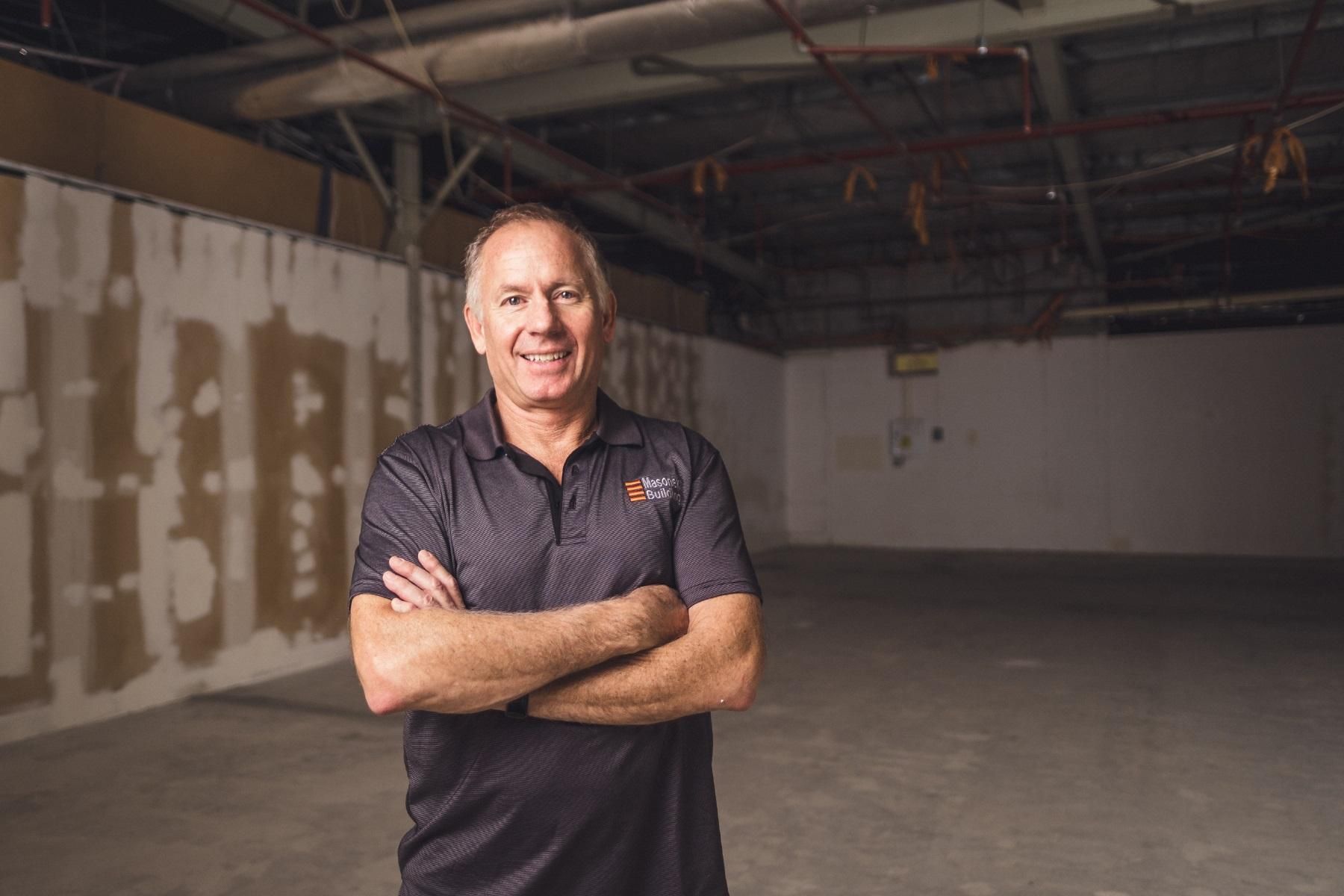 Photo of a man standing in an empty industrial space.