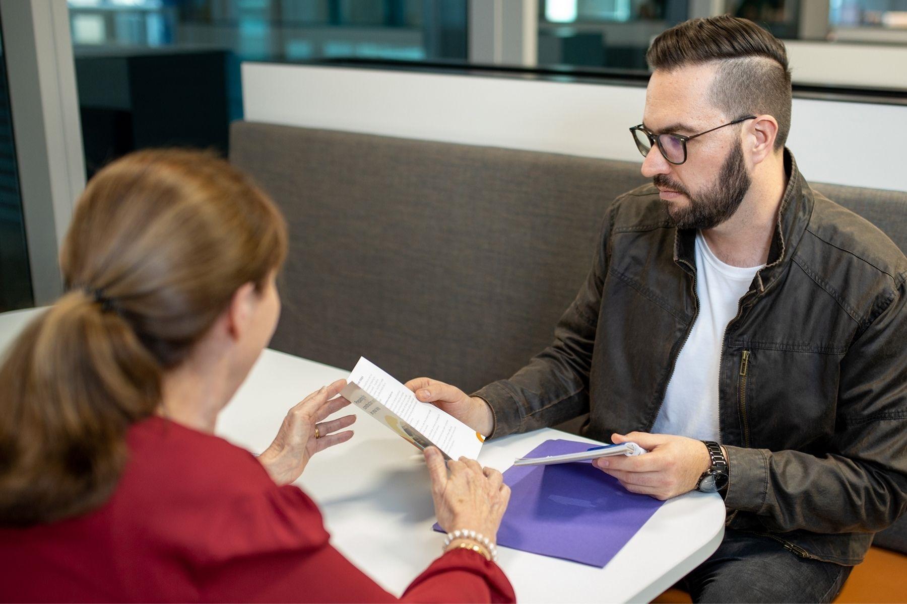 Photo of a man and woman reviewing and discussing documentation.