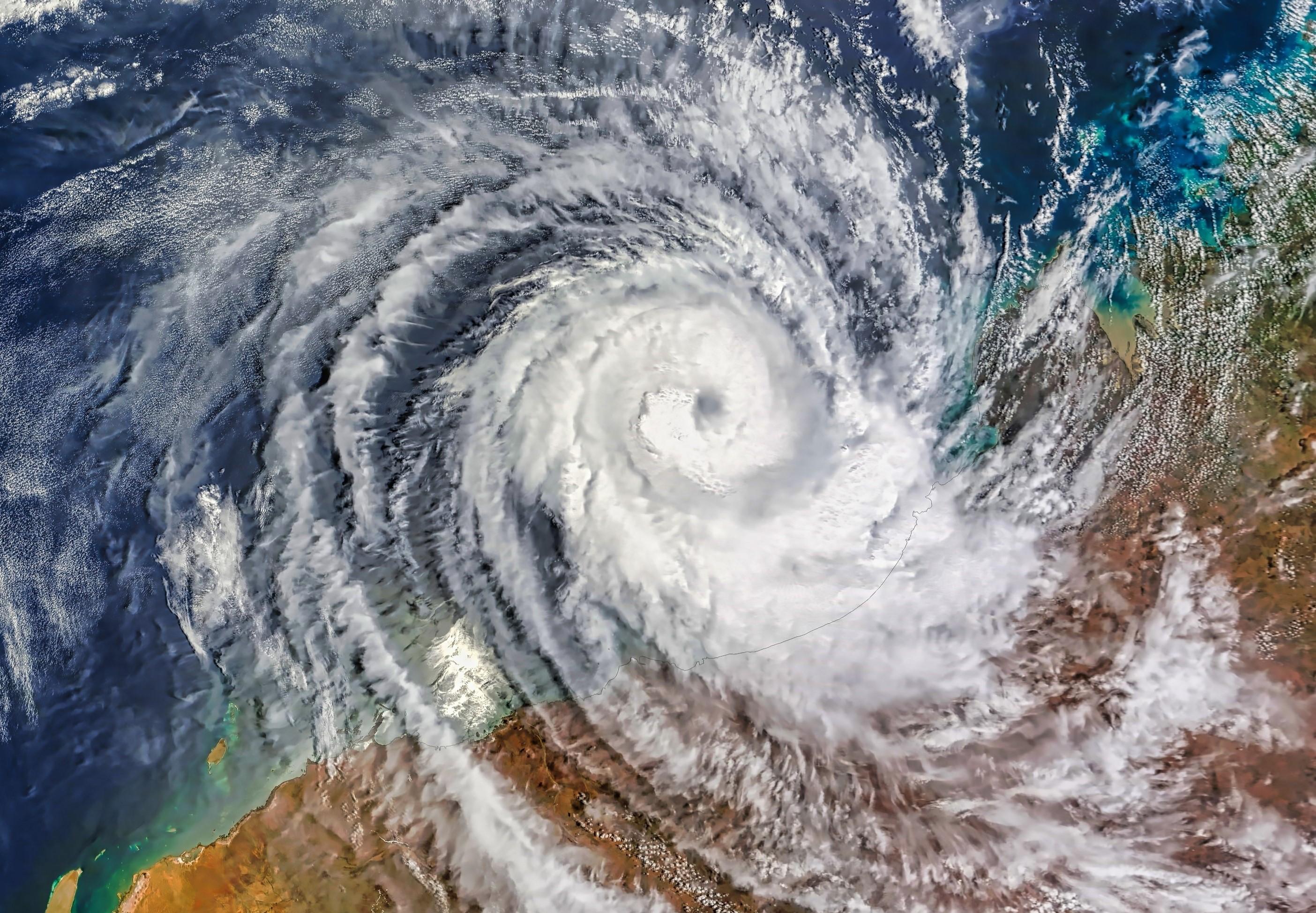 Aerial view of a large cyclone approaching Western Australia, with swirling cloud patterns visible from above.