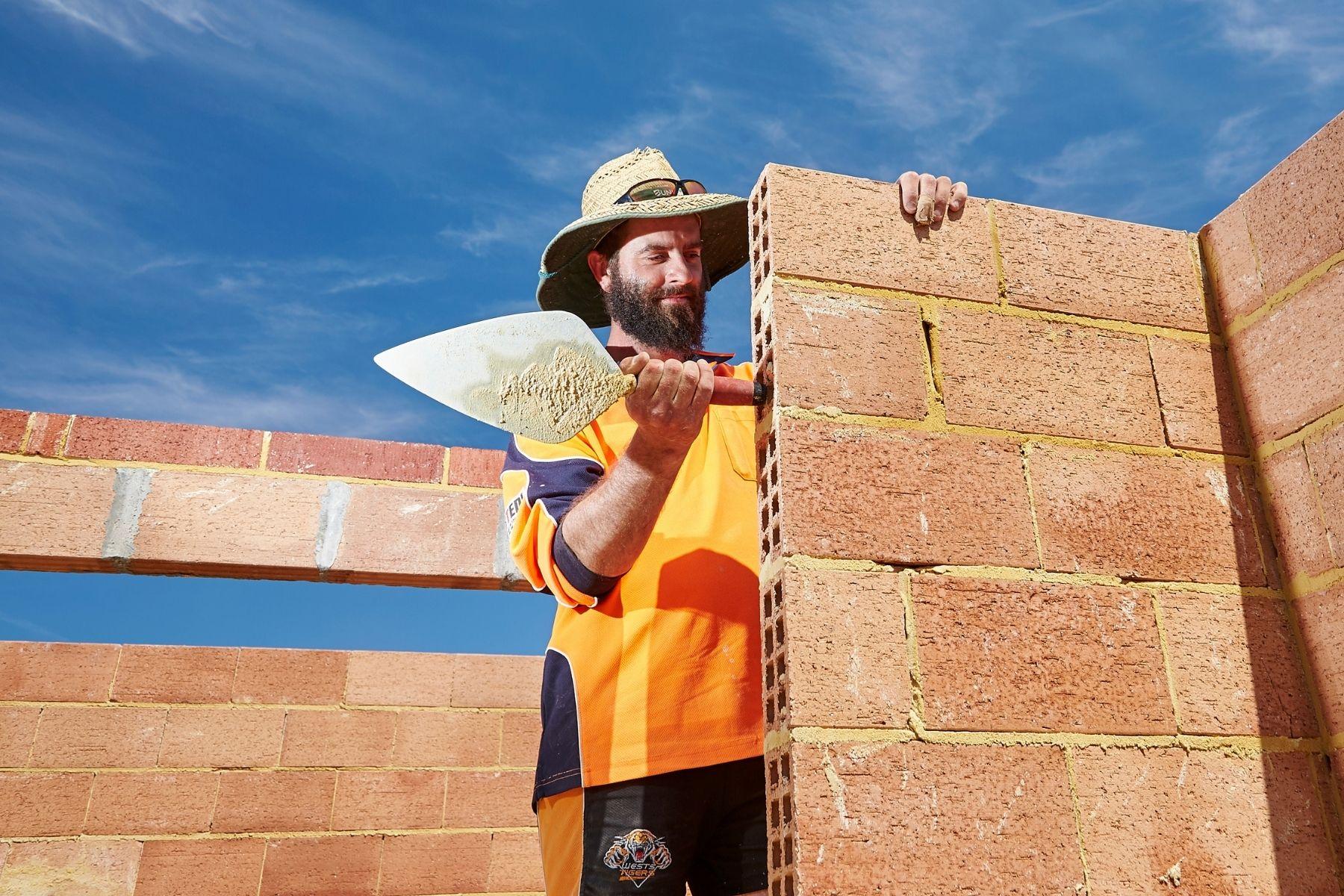 Photo of a brick layer working on site.