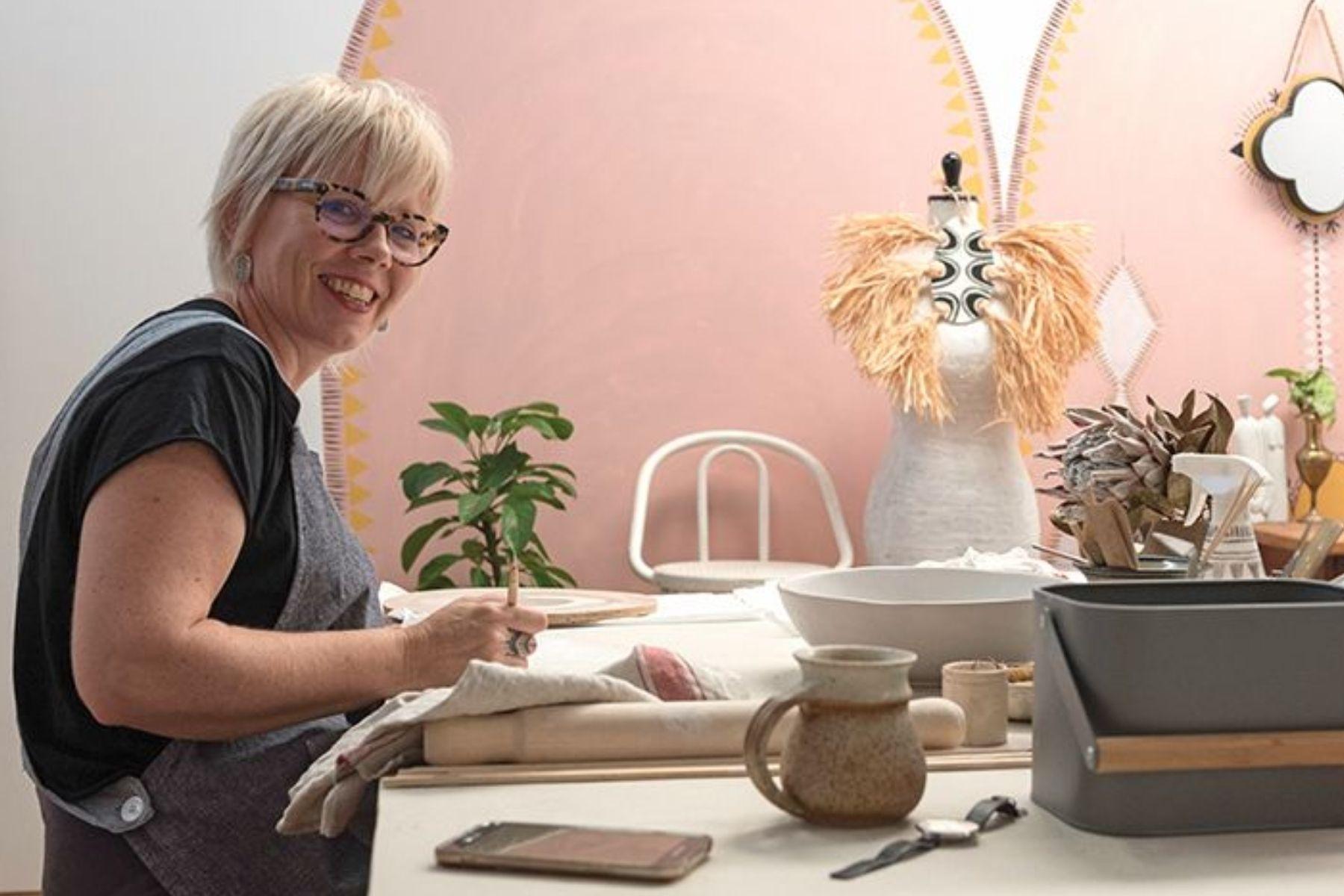 Photo of a woman working on pottery items.