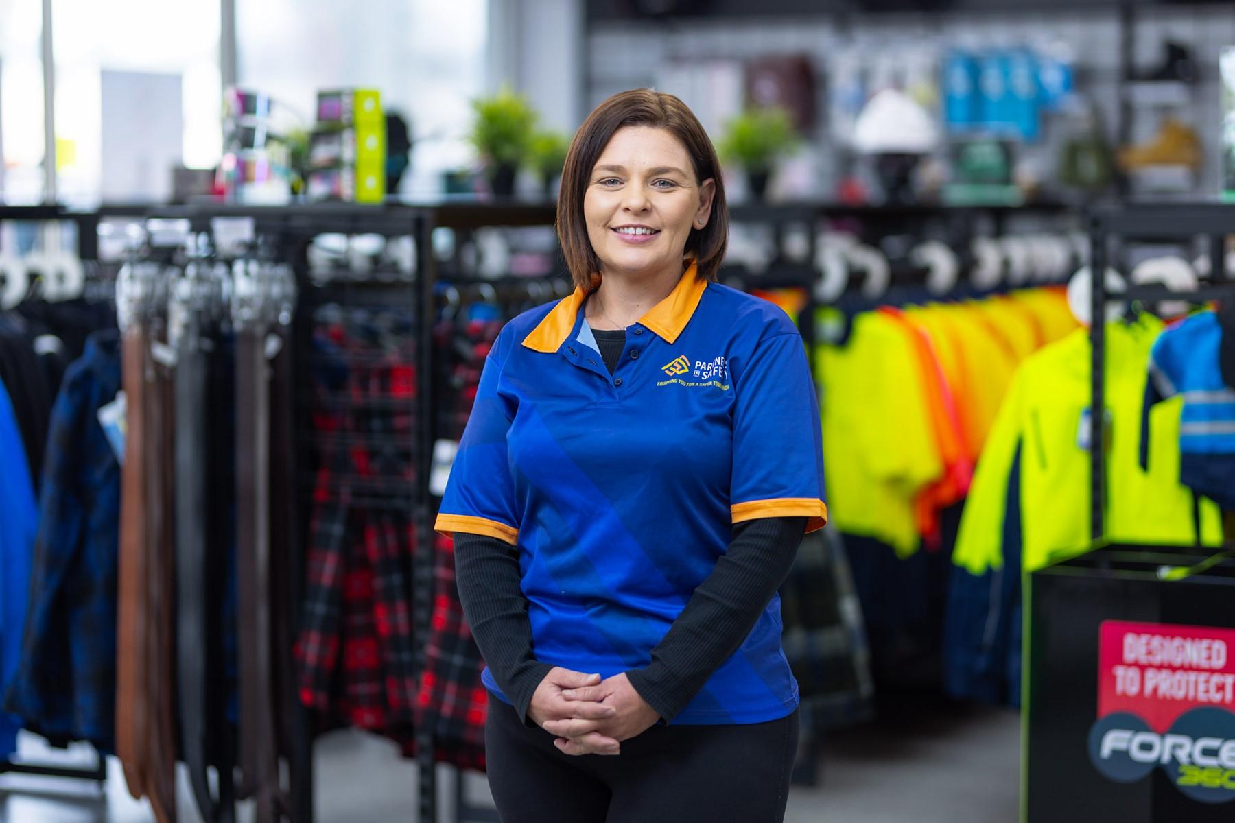 Photo of Alecia Swan, owner of Partners in Safety, standing in her safety equipment store. 