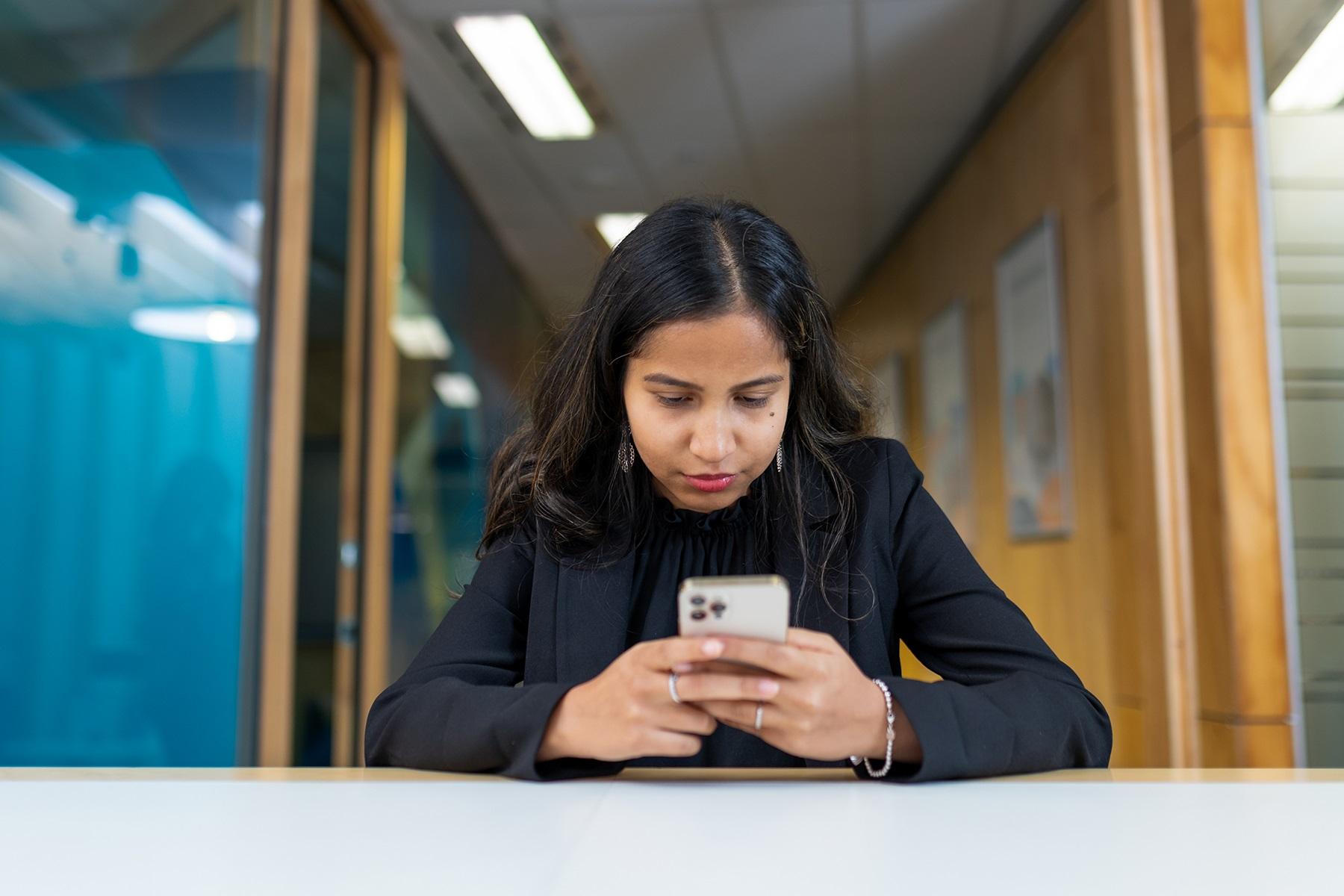 Photo of a woman looking at a smart phone screen.