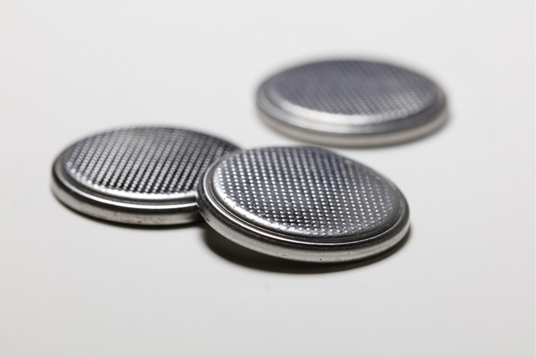 A photo of three button batteries on a counter.