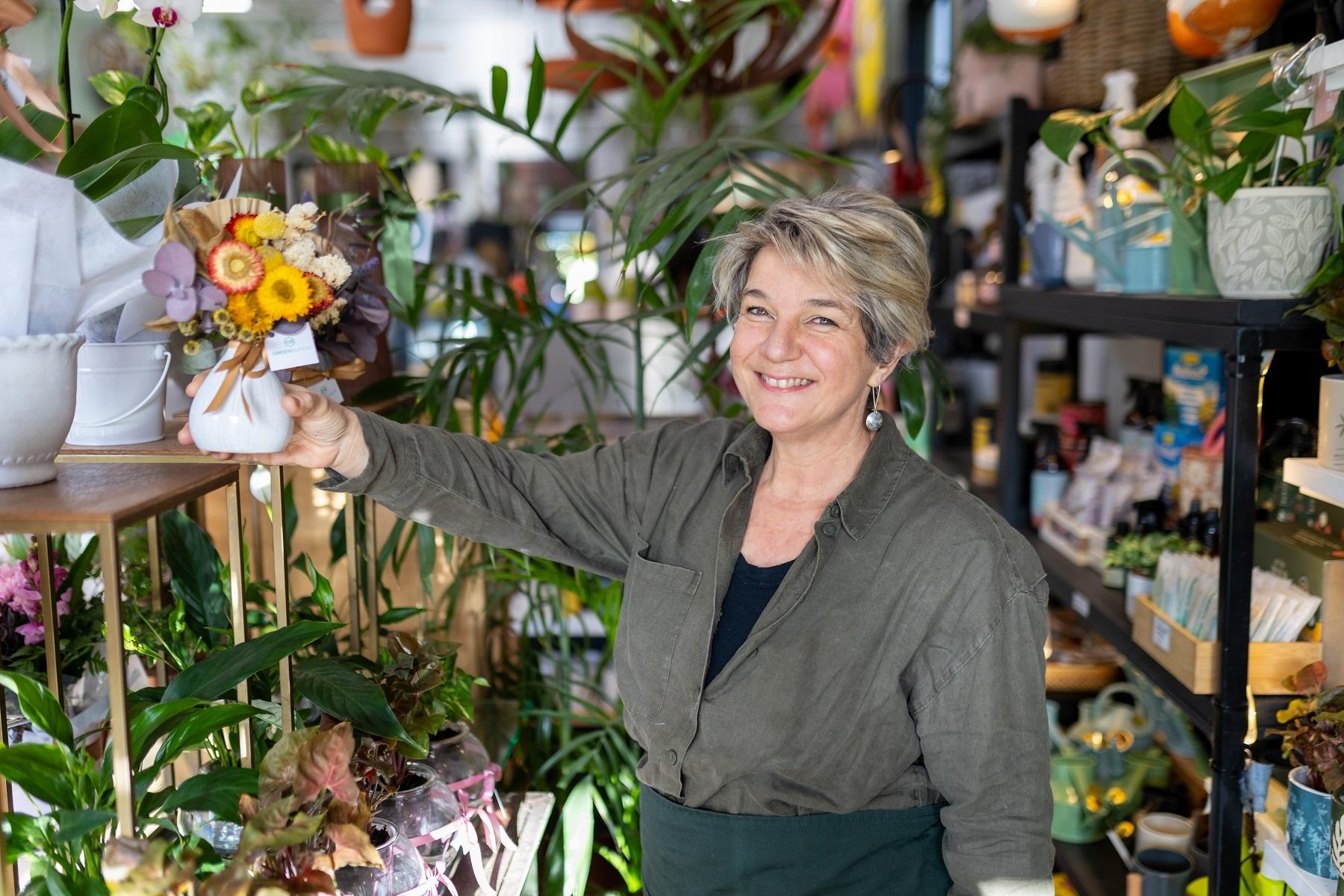 Photo of Shellie Attwood, owner of Greenbunch, standing in her cafe florist business.