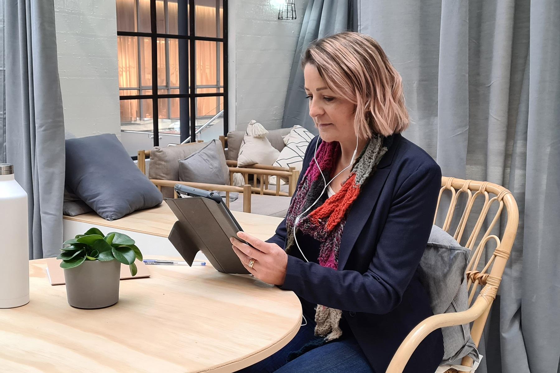 Photo of a woman reading from a tablet device.