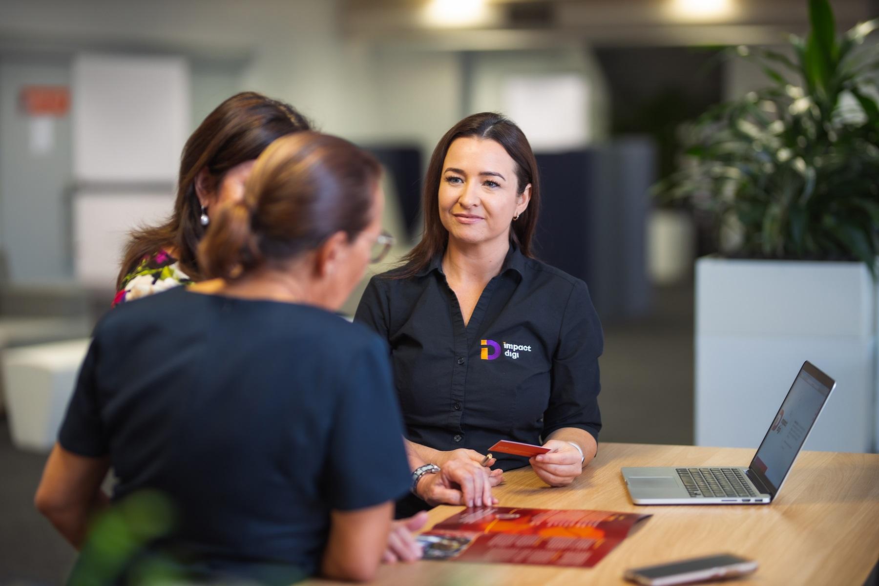 Photo of Tamara Bin Amat, owner of Impact Digi, working with clients.