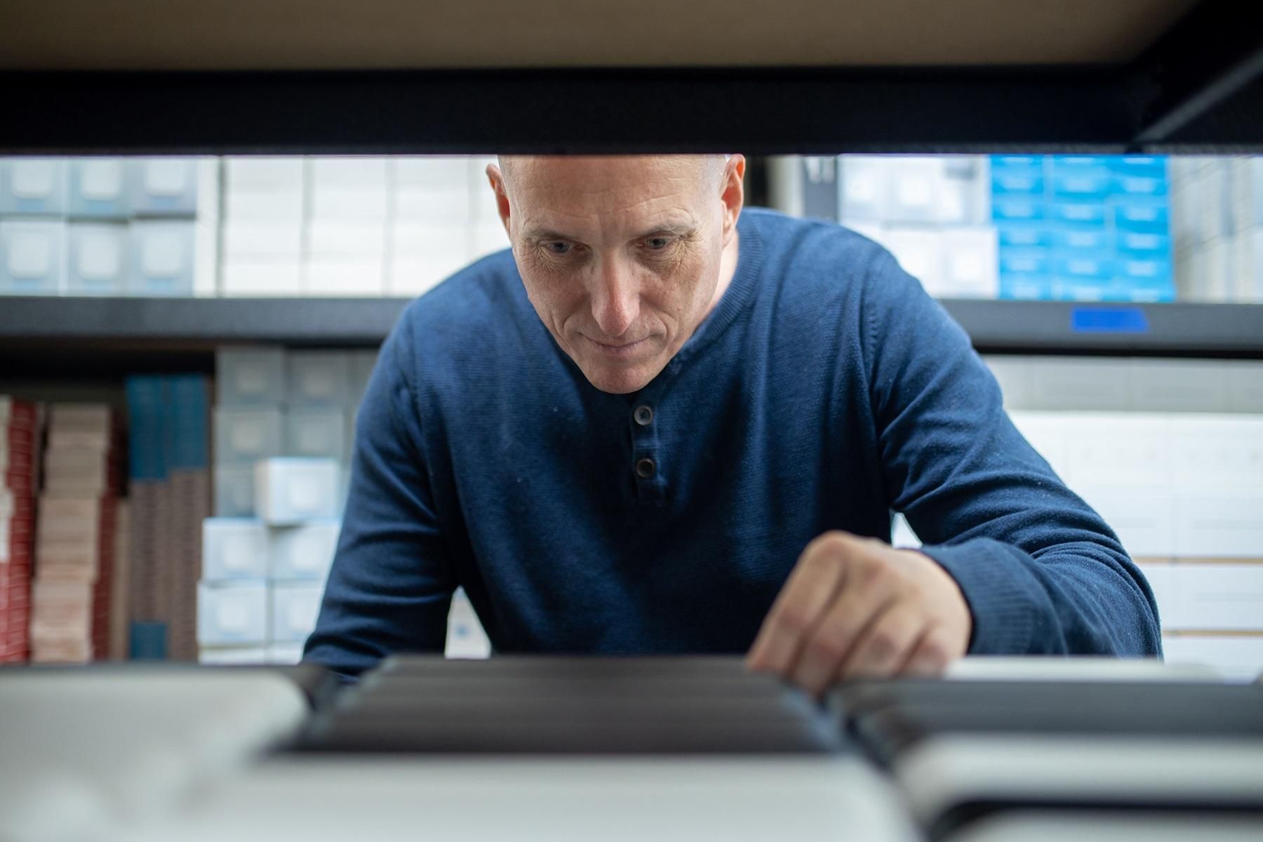 Photo of a man sorting through files.